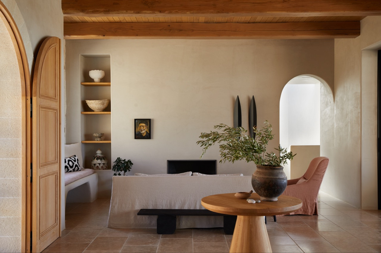 The main bedroom includes built-in corner shelving with wooden supports, custom seating, and an arched passage leading to other private spaces