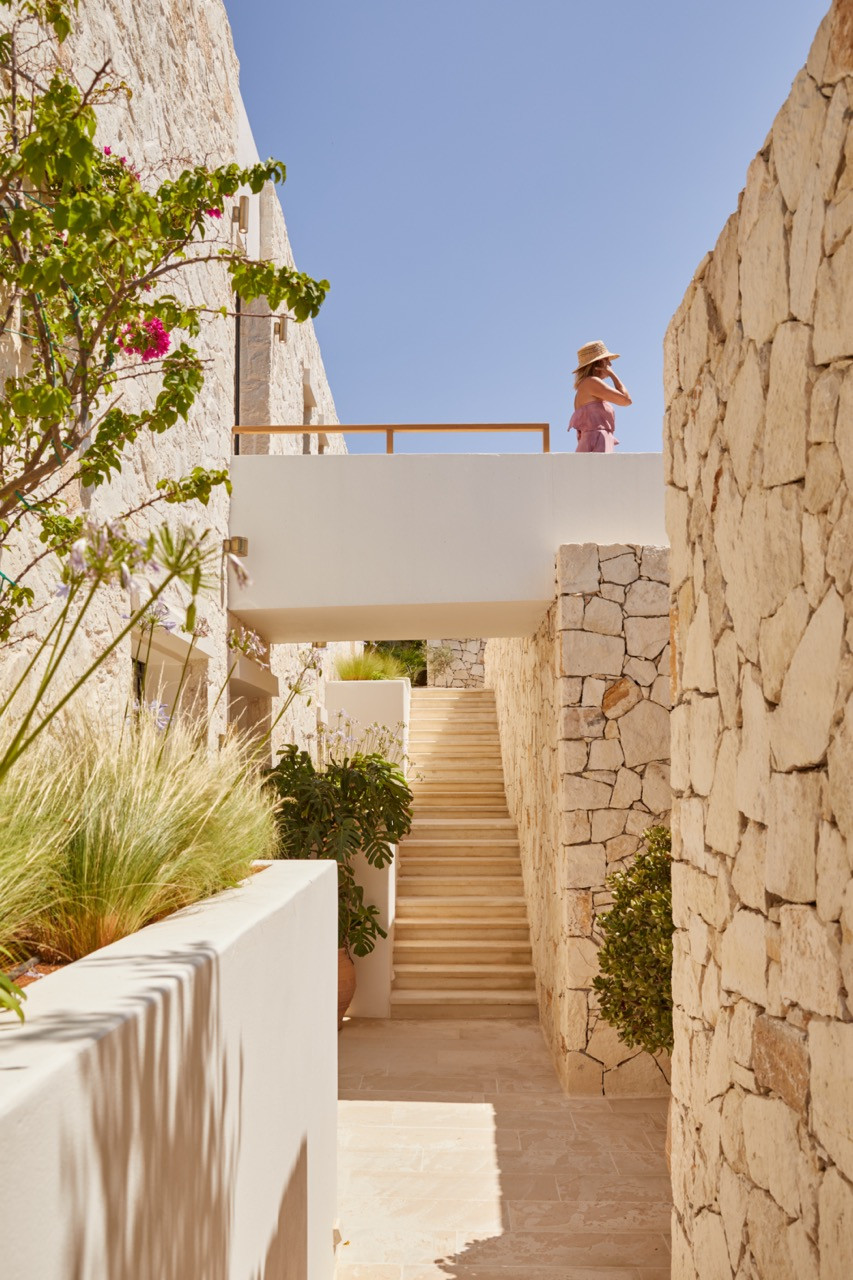 The upper terrace overlooks stone stairs flanked by bougainvillea and Mediterranean plantings