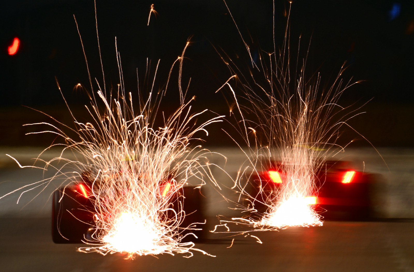 SINGAPORE, SINGAPORE - SEPTEMBER 30: Sparks fly behind Lando Norris of Great Britain driving the (4) McLaren MCL36 Mercedes (L) and Carlos Sainz of Spain driving (55) the Ferrari F1-75 (R) during practice ahead of the F1 Grand Prix of Singapore at Marina Bay Street Circuit on September 30, 2022 in Singapore, Singapore. (Photo by Clive Mason/Getty Images,)