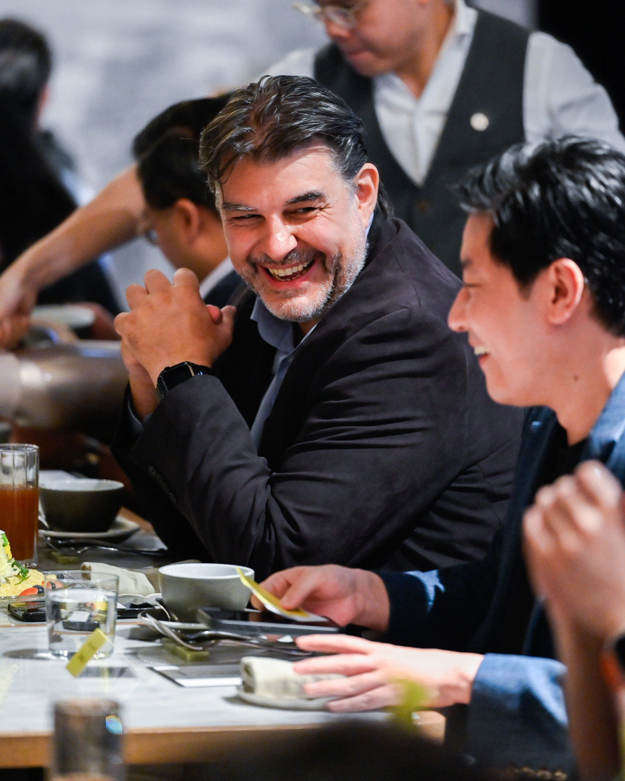 Stephane Louvrier, Okosix’s chief revenue and strategy officer, smiles while talking with other attendees (Photo: Tatler Hong Kong)