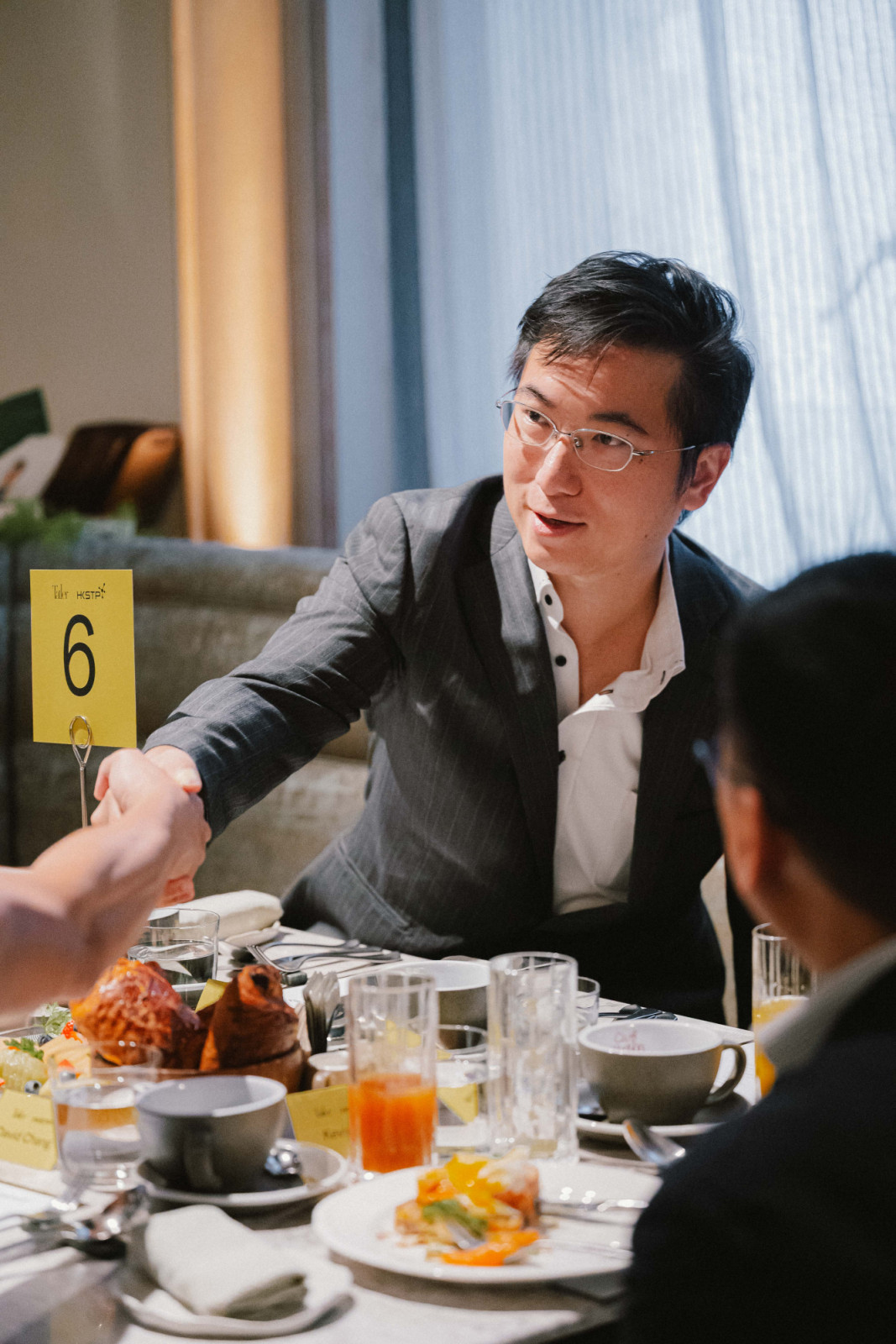Roy Lim, founder and CEO of Robocore, shakes hands with other attendee (Photo: Tatler Hong Kong)