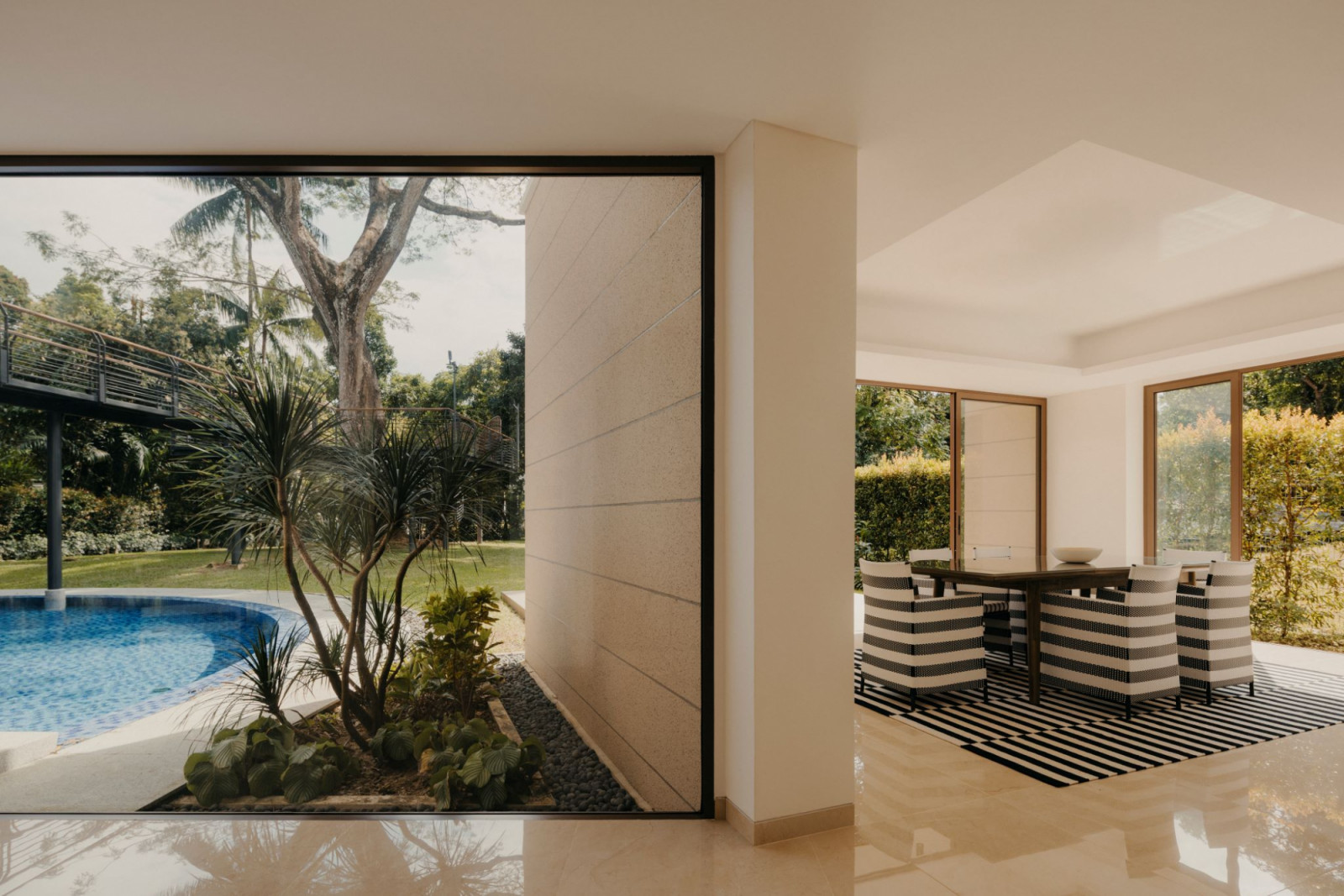 Full-height openings frame glimpses of the outdoors throughout the house;
