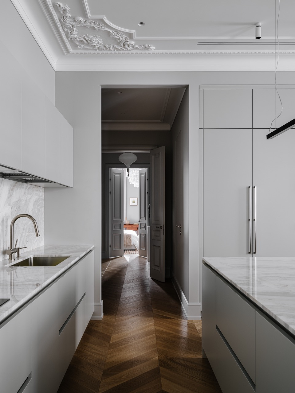 Kitchen view showing enfilade layout through to master bedroom with ornate ceiling mouldings and marble backsplash by Cesar