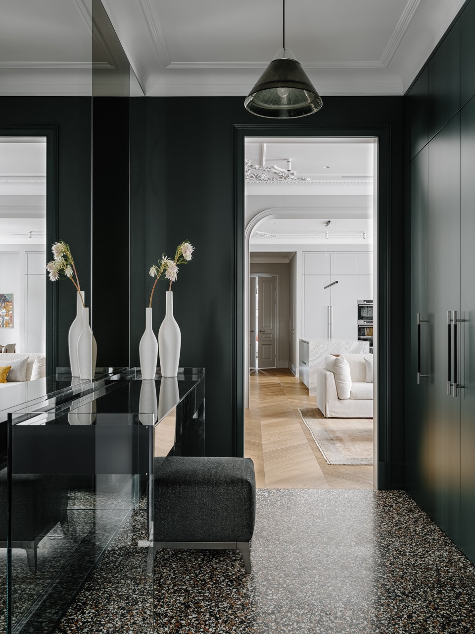 Hallway entrance with terrazzo Architerrazzo flooring, dark emerald panelling, a console by Glas Italia and view through to the living spaces