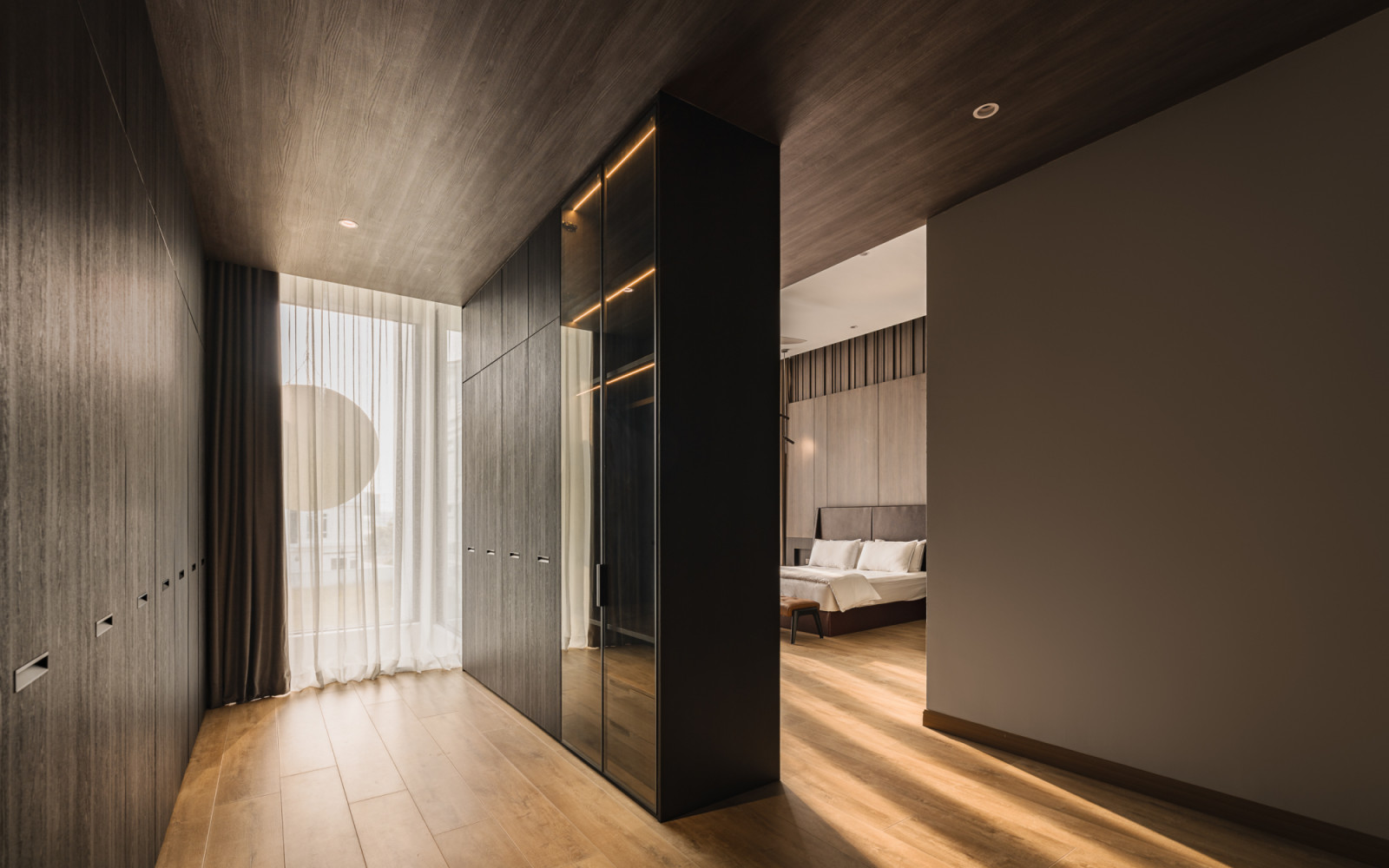 The master bedroom walk-in closet showcases “muted taupes and beiges” with integrated lighting and custom storage solution
