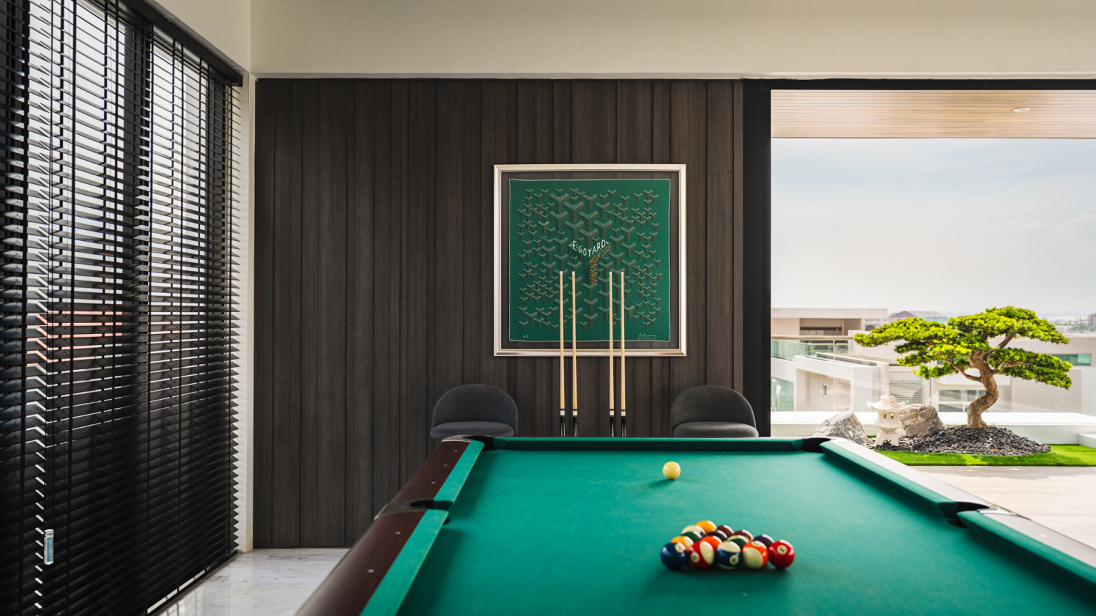 Floor-to-ceiling windows frame panoramic views while the entertainment area seamlessly flows between indoor and outdoor living spaces