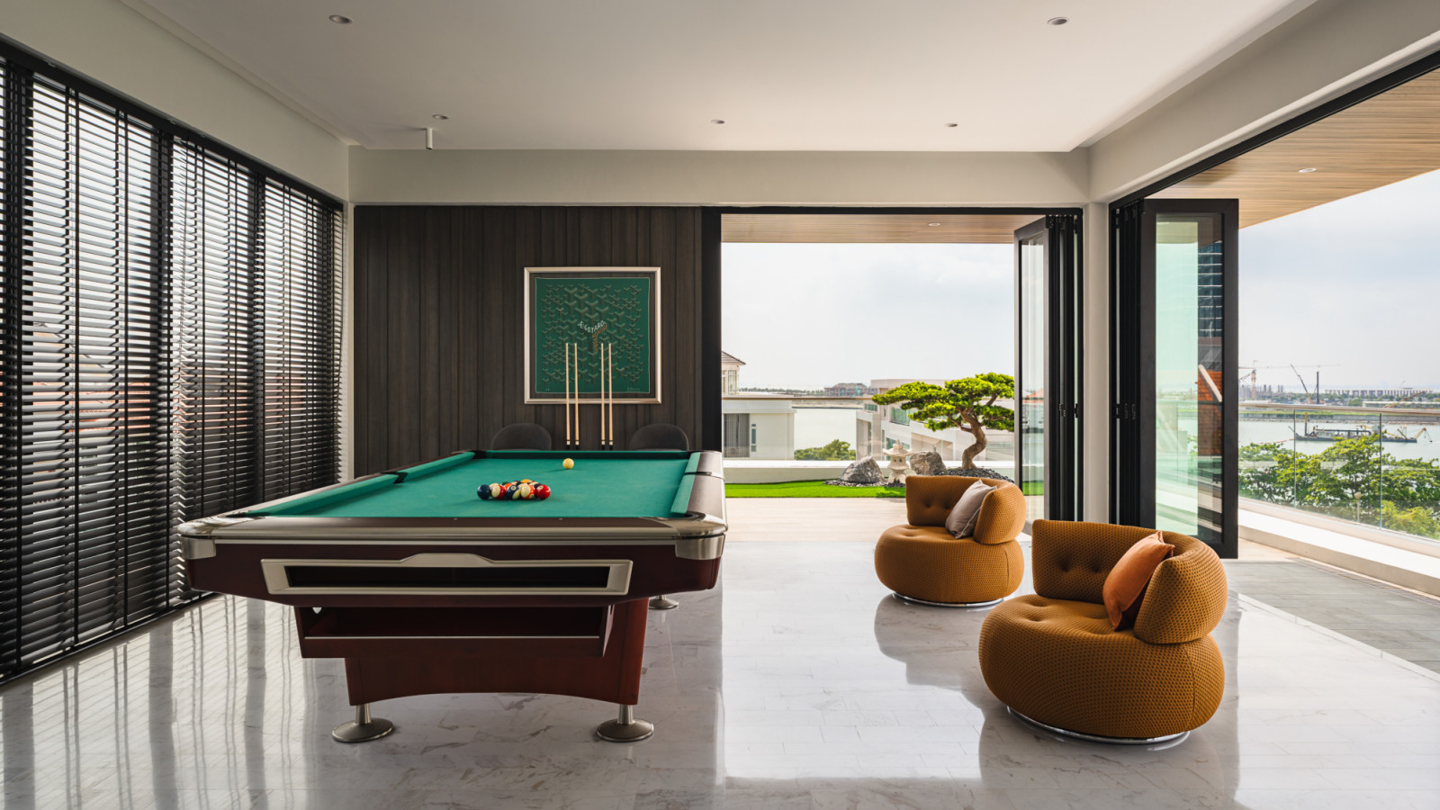 Floor-to-ceiling windows frame panoramic views while the entertainment area seamlessly flows between indoor and outdoor living spaces