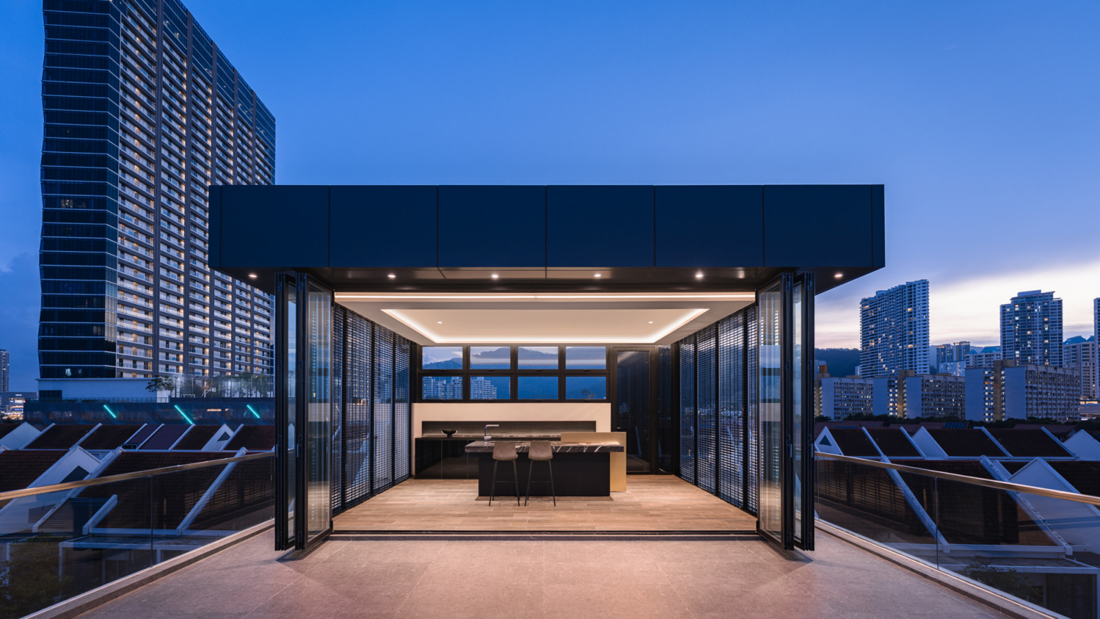 The rooftop entertainment area’s sophisticated lighting design makes it appear to float above the urban landscape