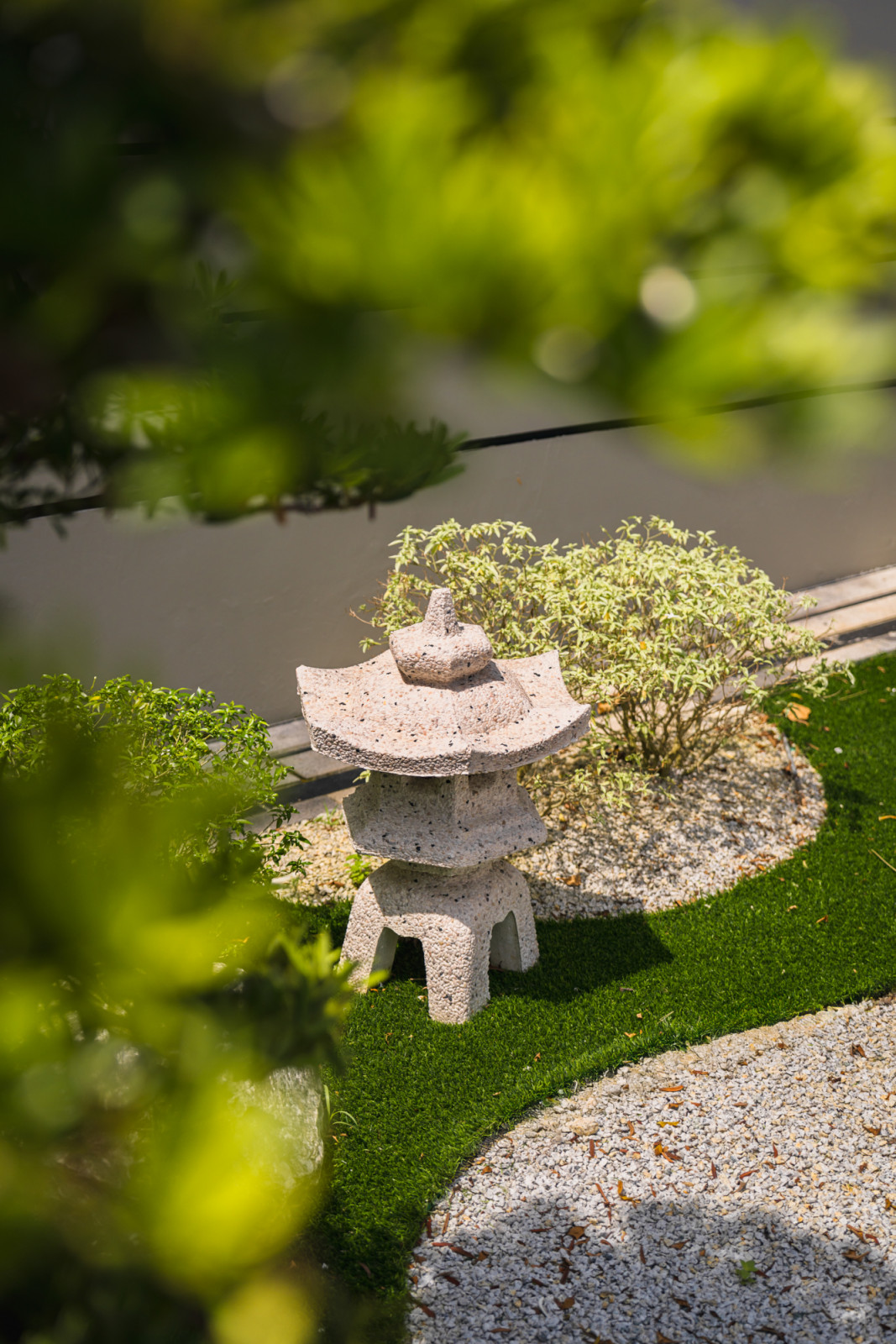 Traditional Japanese stone lanterns create moments of contemplative calm in the zen garden, contrasting with the vibrant art collections inside
