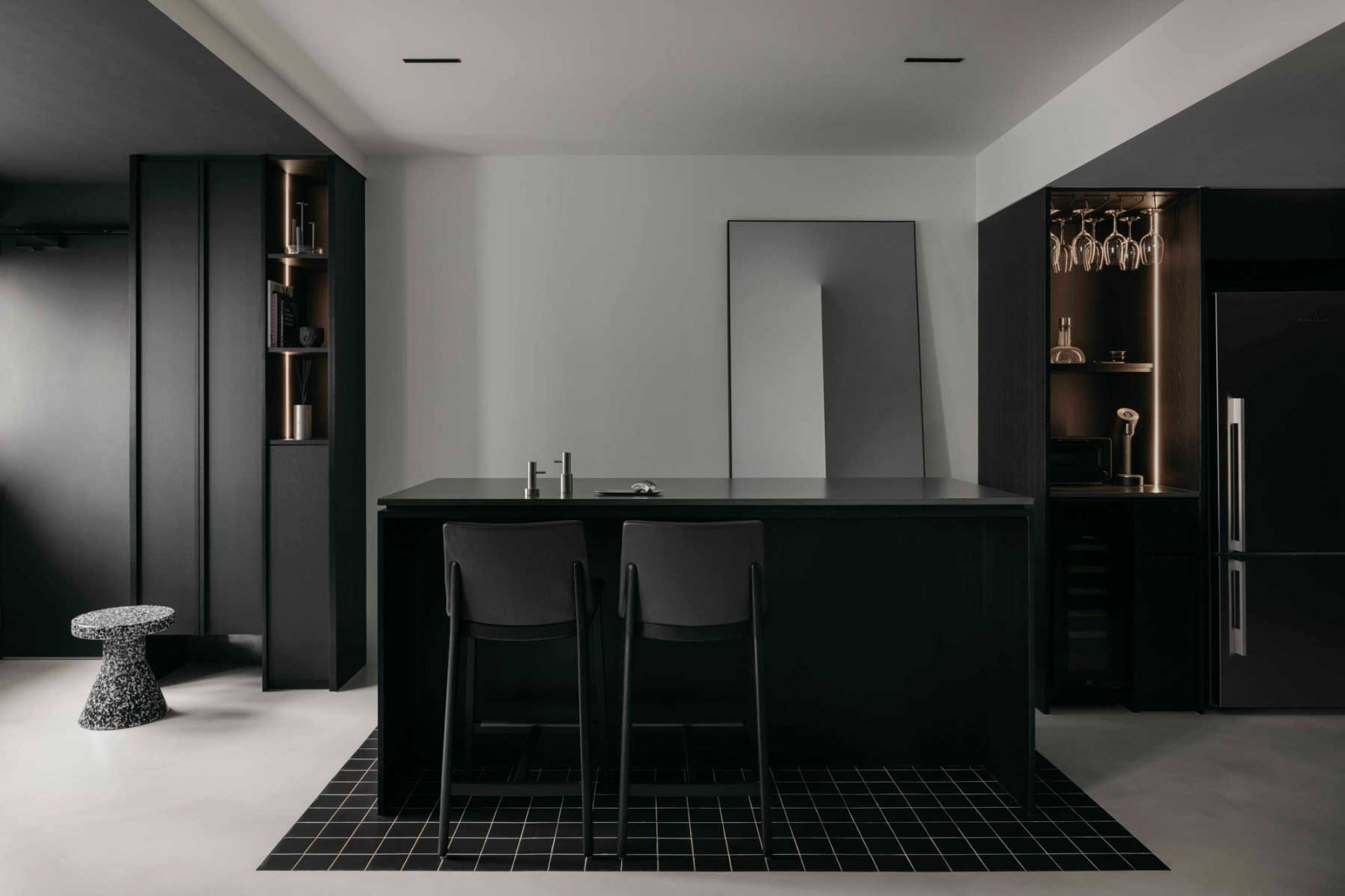 The monolithic kitchen island anchors the apartment, supporting everything from casual meals to doubling as a grooming station for the resident’s dog (Photo: Arche)