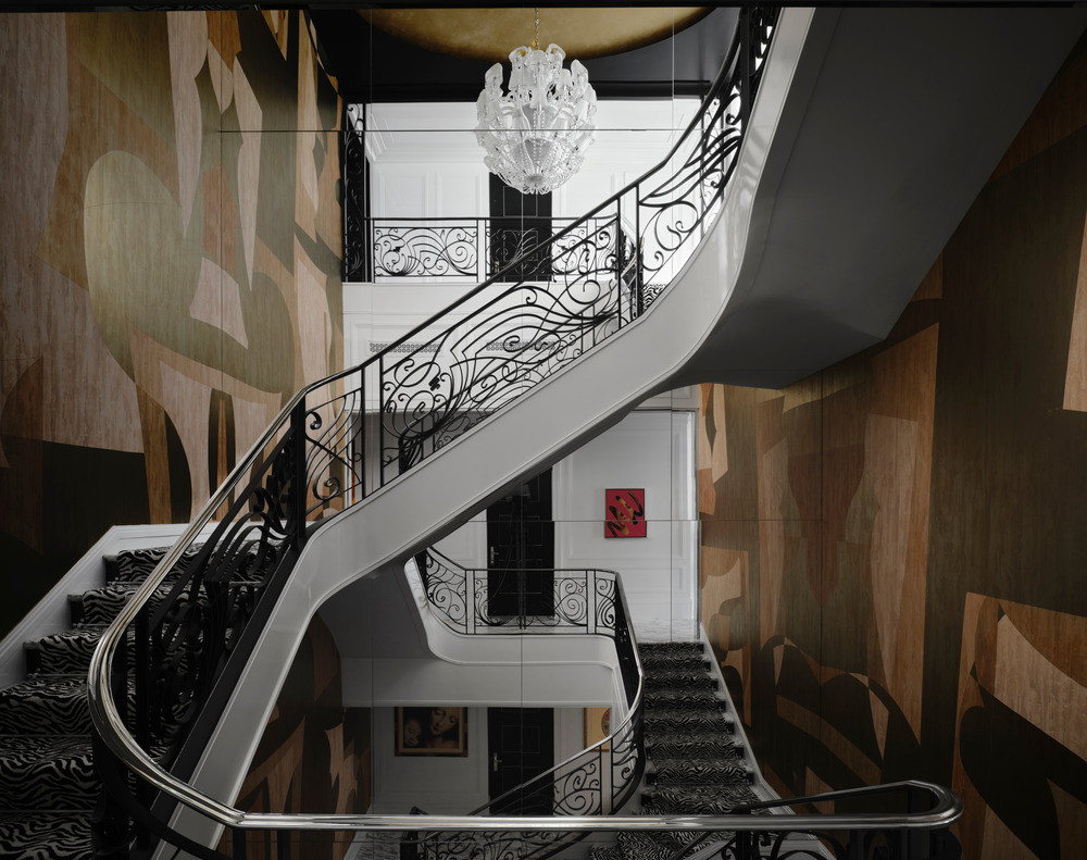The grand staircase with hand-painted silk wall coverings, and railings conceived as an abstracted musical score spiralling upwards