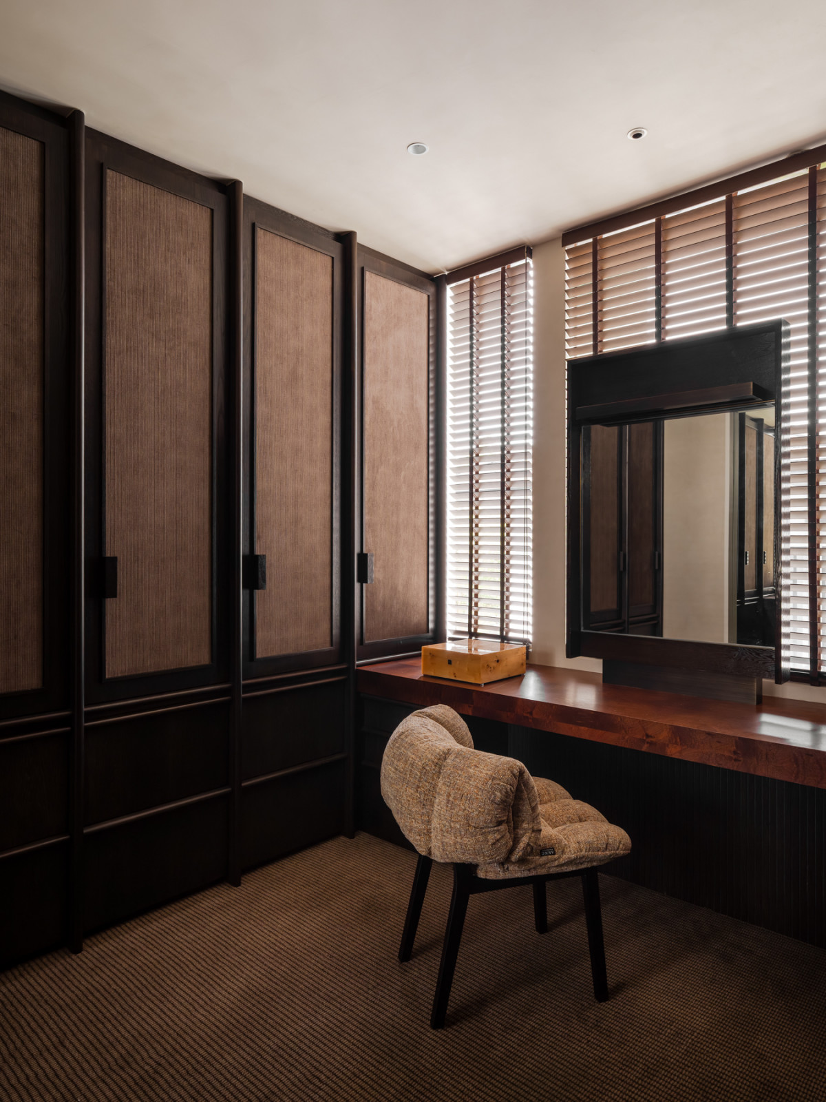 The adjacent walk-in wardrobe with mid-century inspired storage solutions and vanity