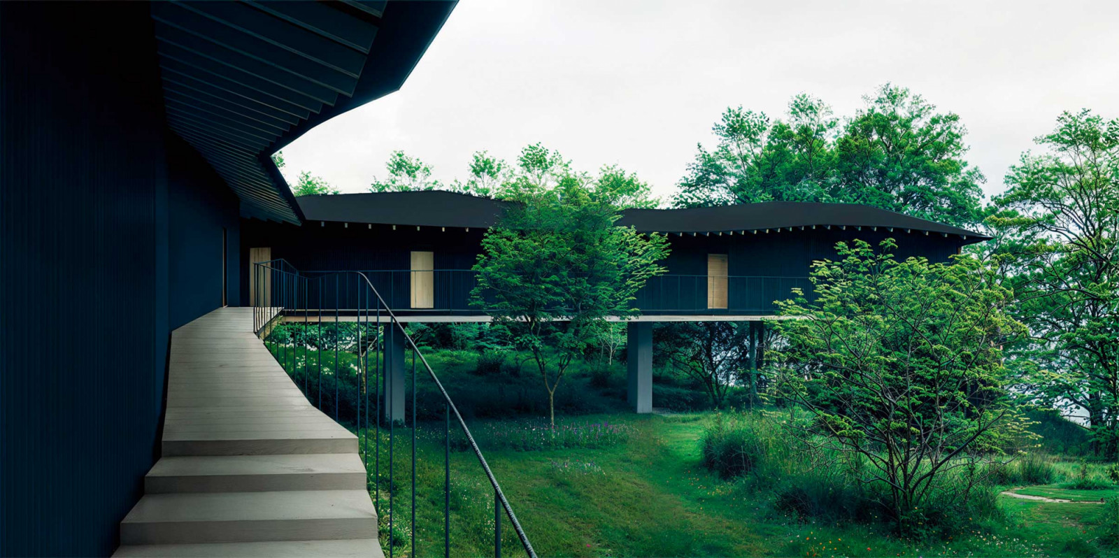 Sporting a dark finish, Shishi-Iwa House No.04 will be “muted” among its surroundings but its windows will “appear like lanterns in the trees” come nightfall (Photo: Kazuyo Sejima & Associates)