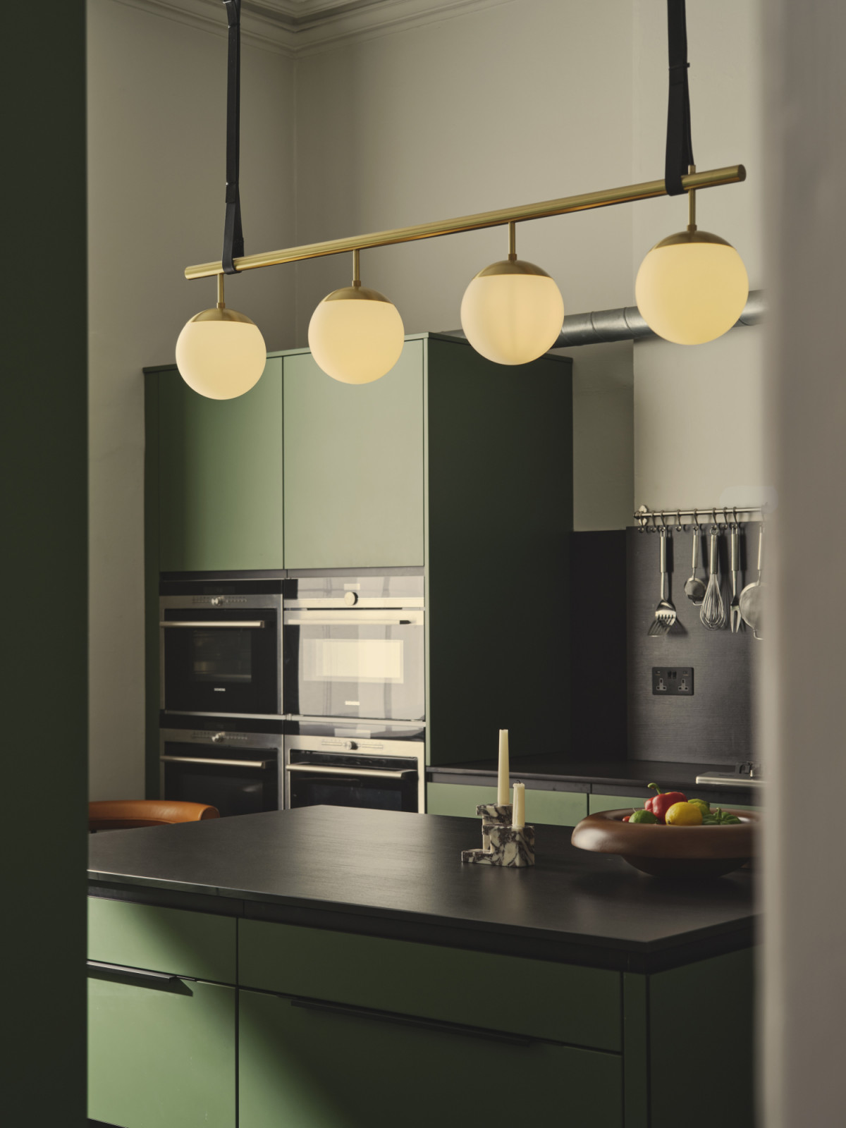 The bespoke kitchen by PJ Construction in a Dublin, Ireland home designed by Maison RA-D with a Long Lord Pendant light by RUBN, Indochine Chair by Cassina, Harbour Round Table by Audo CPH, Brick Candle Holders by 101CPH, and Rond Bowl by Audio CPH