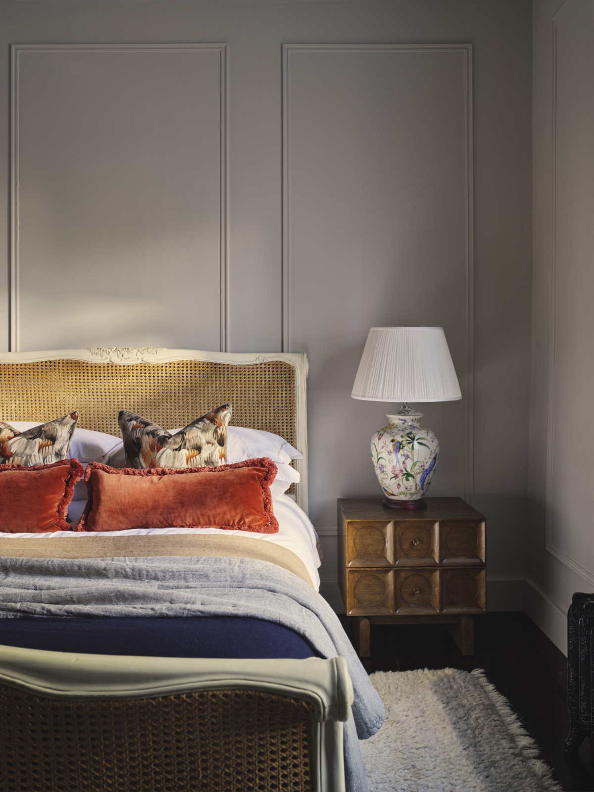 A bedroom in a Dublin, Ireland home designed by Maison RA-D, with Margeaux Oblong Cushions, Liz cushions by Soho Home, cashmere throws and merino bed throw by Johnstons of Elgin, Optical Ego Rug
by Linie Design, and an antique bed frame and table lamp purchased from the previous owner