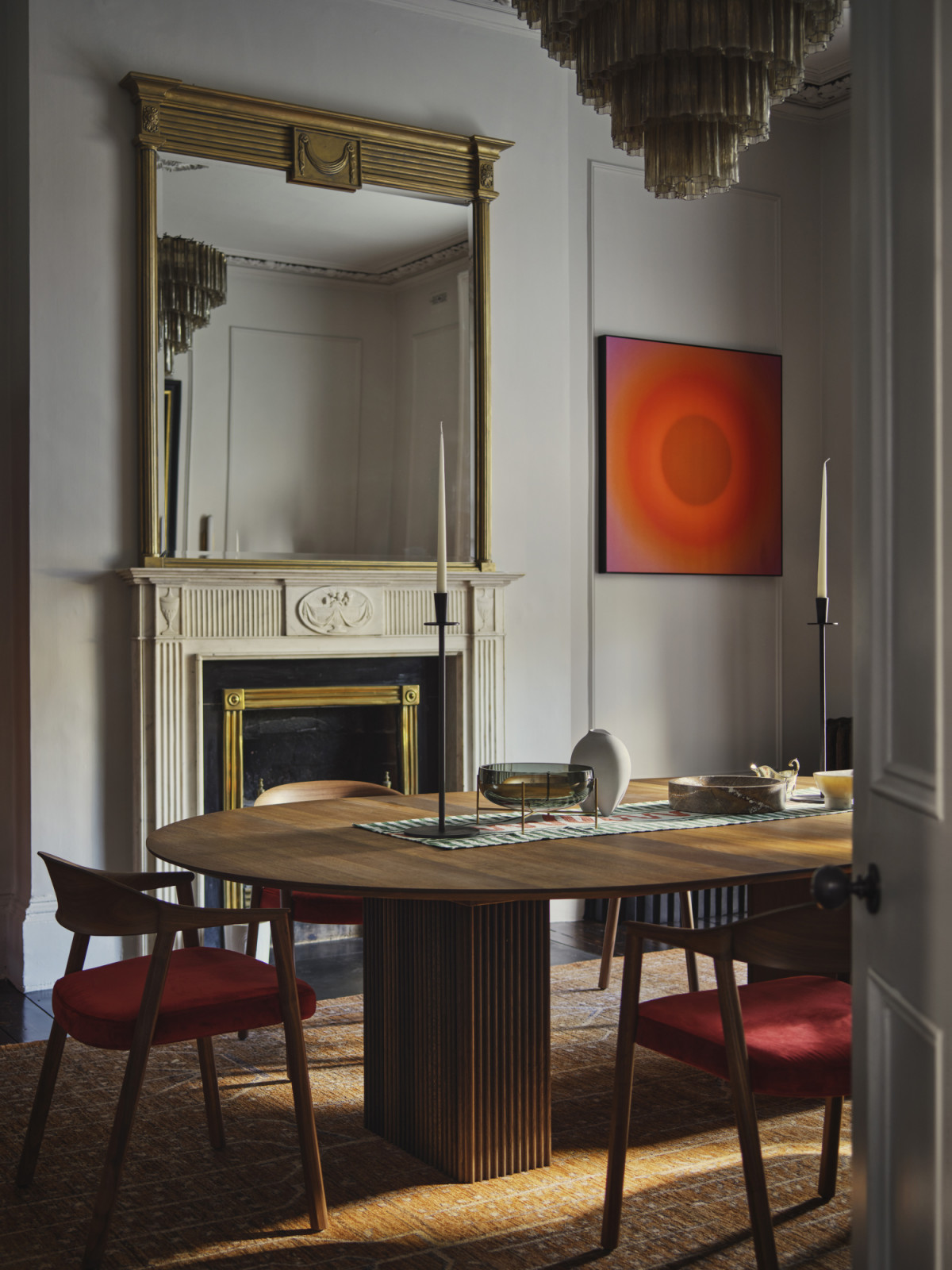 The dining room of a Dublin, Ireland home designed by Maison RA-D, with a Pentagon Chandelier by Bella Figura, Bresle Rug by Soho Home dining table by DK3, Hera Dining Chairs by Pedrali, Escapism Table Runner by T C S, bowls and candleholders by Ferm Living, Echasse Bowl by Audo CPH, Sumo Vase by 101CPH and Tribu Bench by 101 CPH