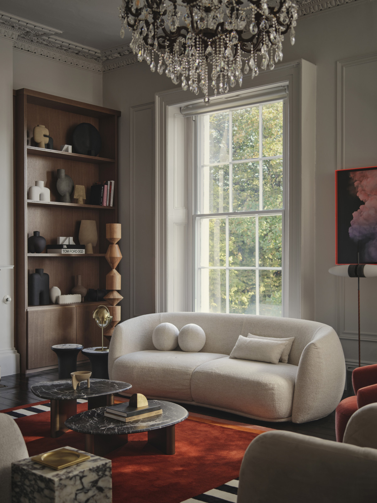 The living room of a Dublin, Ireland home by Maison RA-D, with Strict Rayures Rug by CC Tapis, Pacific Sofa by Patricia Urquiola for Moroso, Plinth side table by Audo CPH, Pouf by Studio Pepe for Gallloti Radice, Arc Floor Lamp by Soho Home, Callisto Coffee tables by Porada, Constantina Floor Lamp by Einrichten Design, Bull Floor Lamp by Square in Circle, Lagoa lounge chair by Tachinni, Ruff Armchair by Moroso, Geometric side table by Ethnicraft, bespoke joinery by DFL, and display objets by 101 CPH
