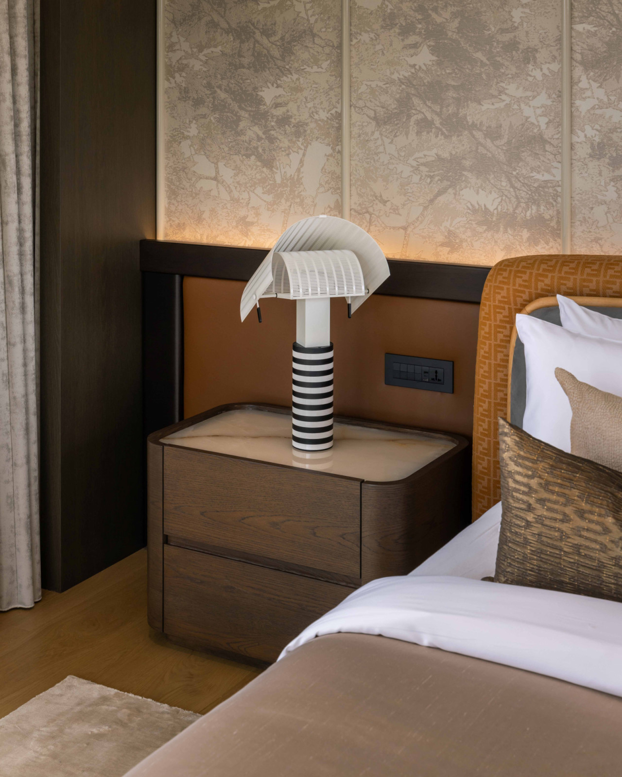 This bedside vignette reveals a well-curated material palette that evokes rest and comfort