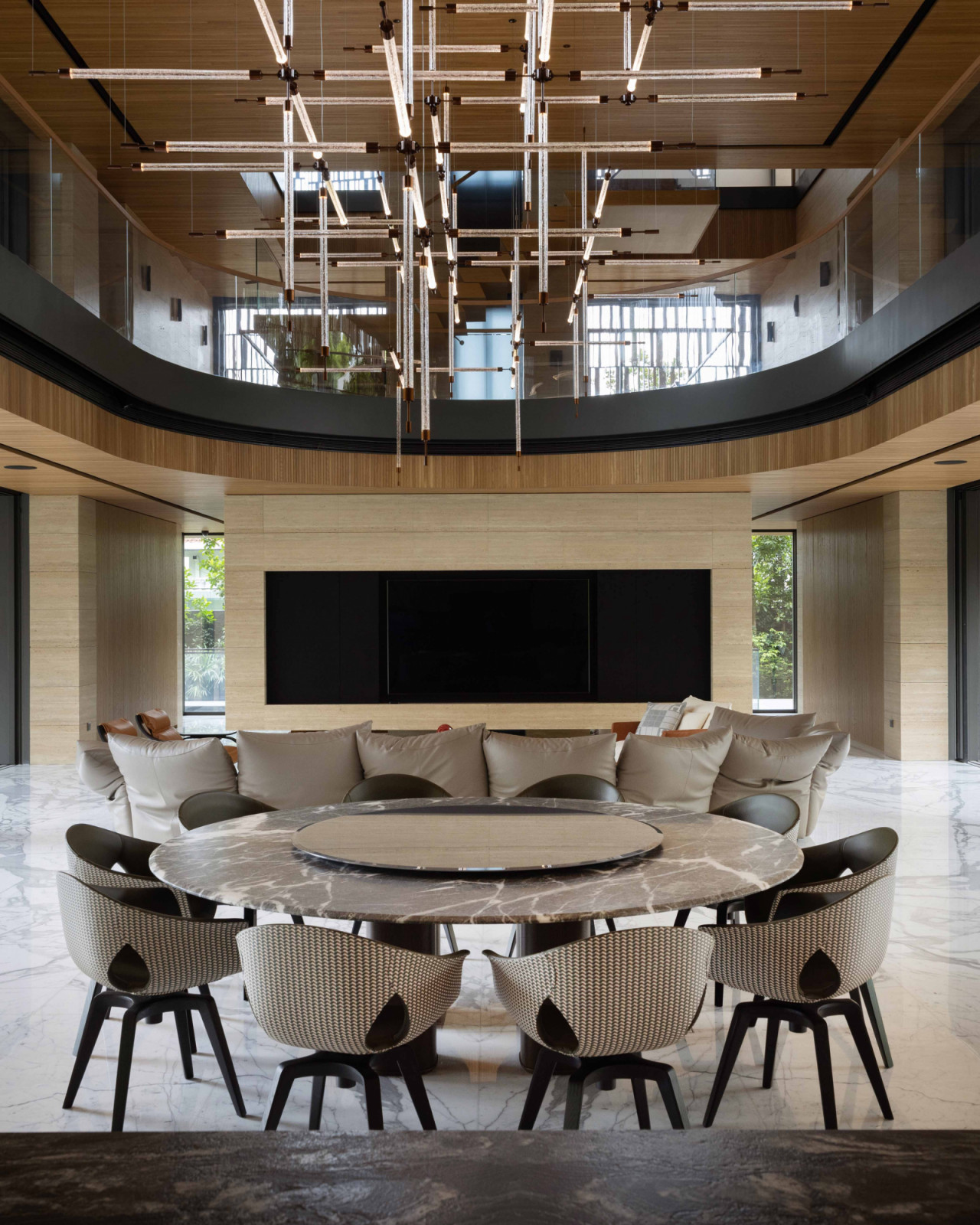 A dramatic view from the dining area, anchored by a circular dining table that echoes the home’s recurring curves