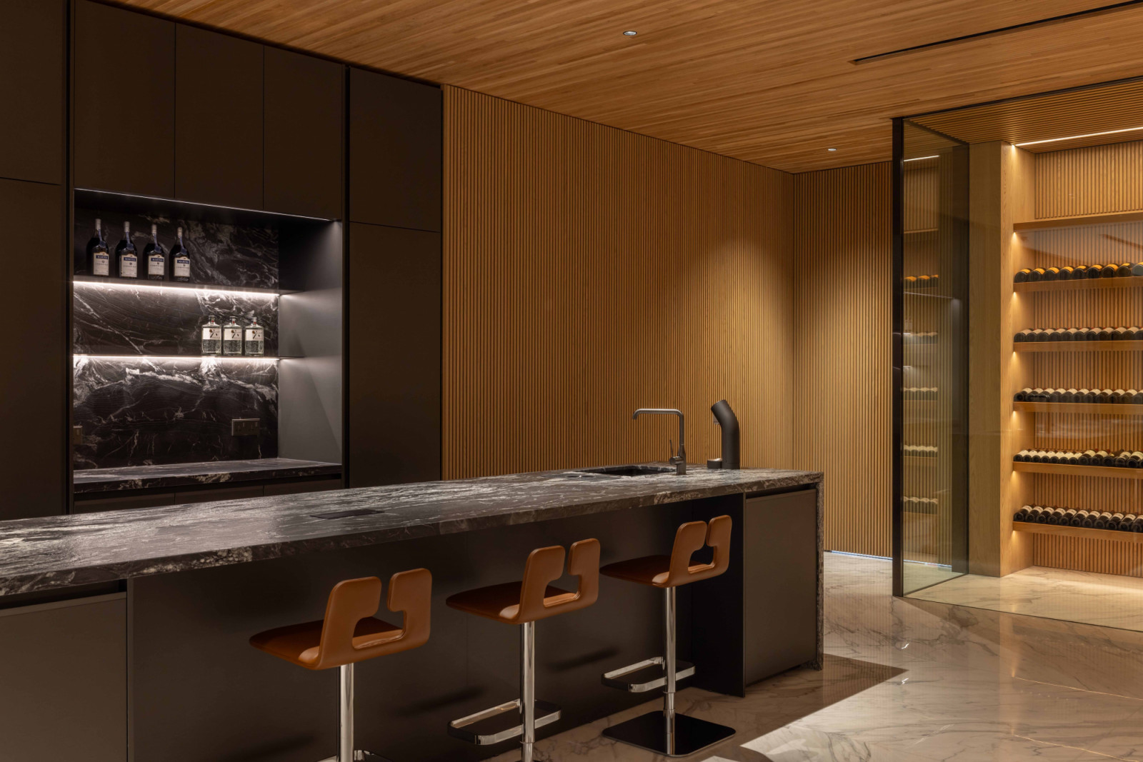 The handsomely appointed bar, clad in dark marble, exudes a sense of understated luxury