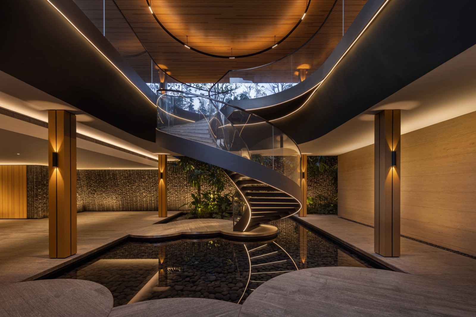 The reflecting pool amplifies the visual impact of the expertly lit spiral staircase, doubling its sculptural presence