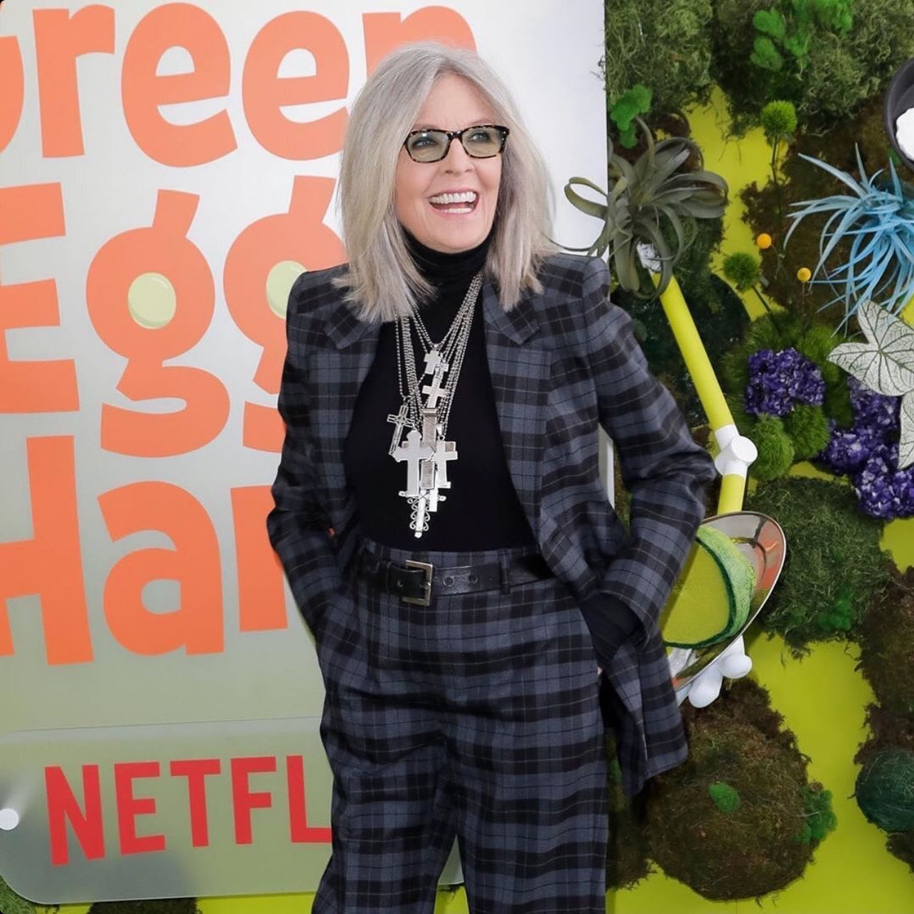 A grey plaid suit anchored by an essential black turtleneck and layered crosses (Photo: @diane_keaton / Instagram)
