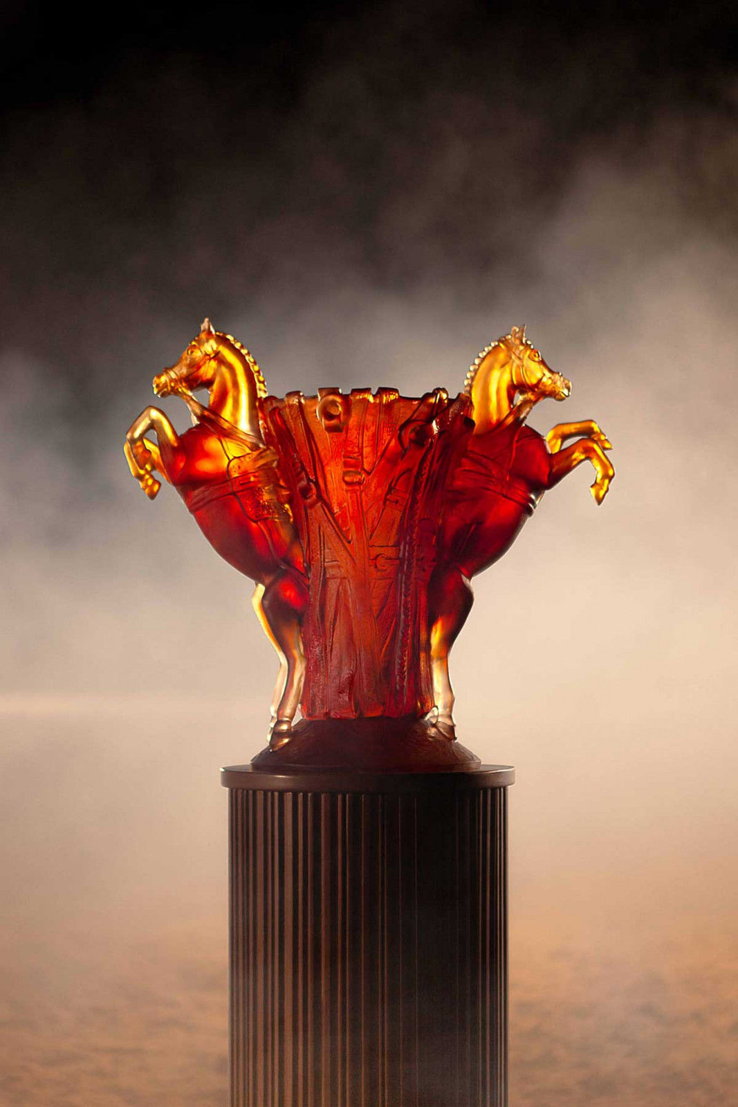 Translucent amber highlights reliefs and textures in the sculpture