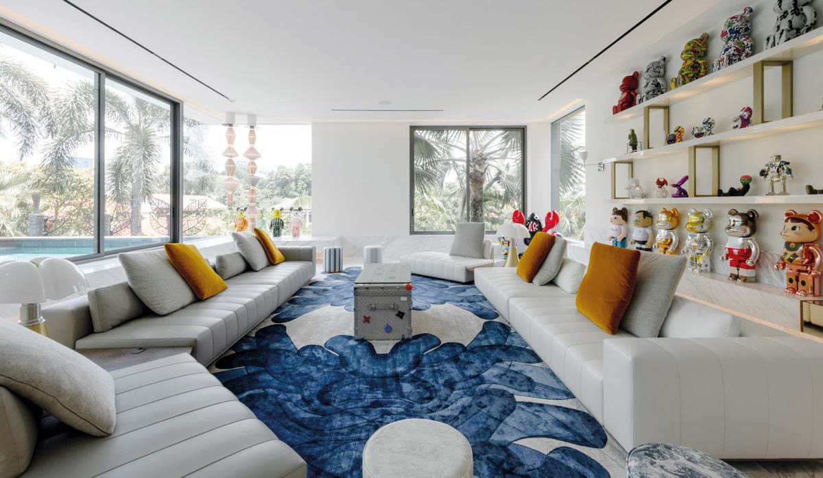 Cheery Bearbricks enliven this Good Class Bungalow’s living room, which offers views of the Bensley-designed pool