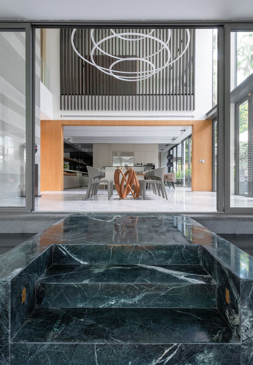 The Good Class Bungalow's double-height dining room opens up to the sunken outdoor area