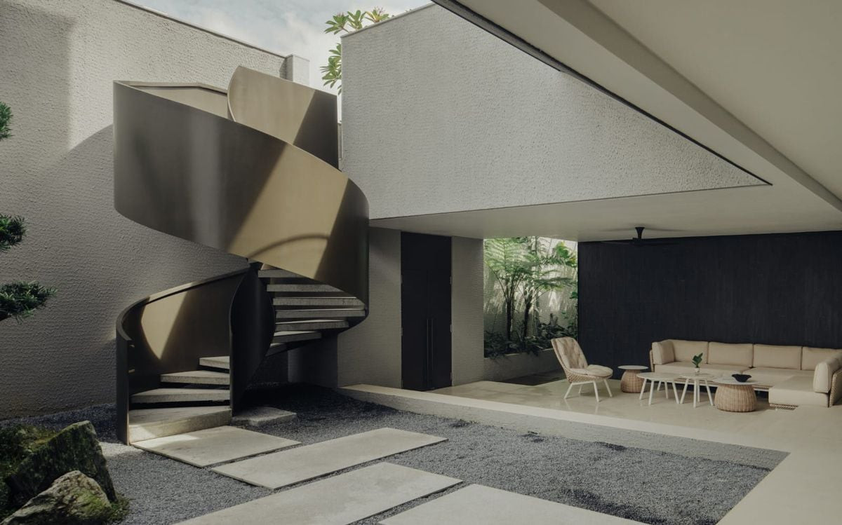 A view of the Good Class Bungalow's basement outdoor living area and its statement spiral staircase from the courtyard garden
