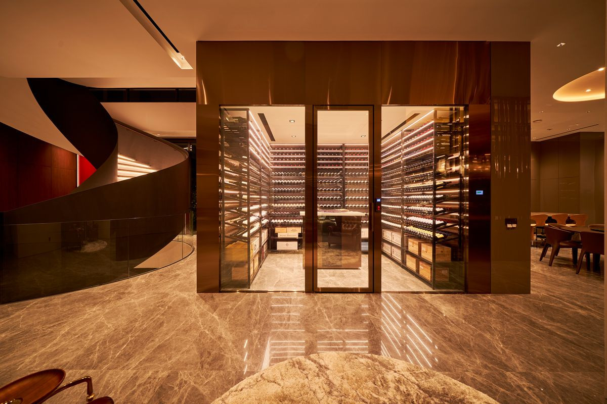 Adjacent to the staircase is the climate-controlled wine room, a haven for the owner’s prized collection