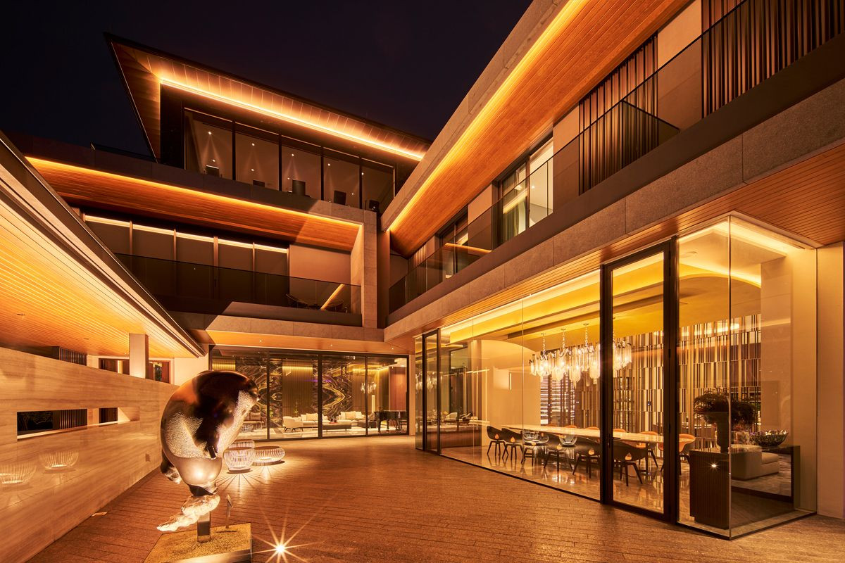 The facade of this Good Class Bungalow glows gold in the evening, and the sculpture by Taiwanese artist Li Chen takes pride of place in the courtyard