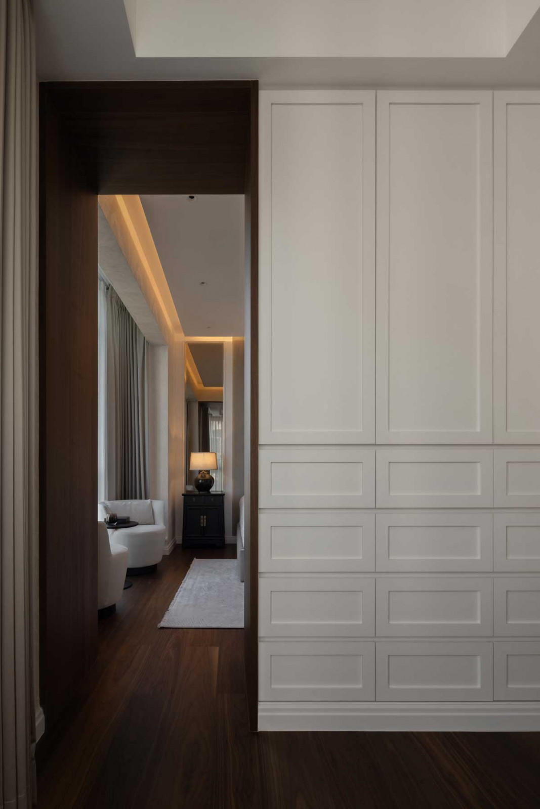 The master wardrobe features elegant white-panelled carpentry; the dressing area is defined by graceful curves and brass detailing
