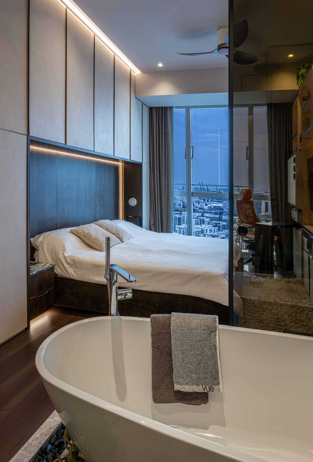A well-appointed bedroom suite with a corner study and bathroom with a freestanding tub