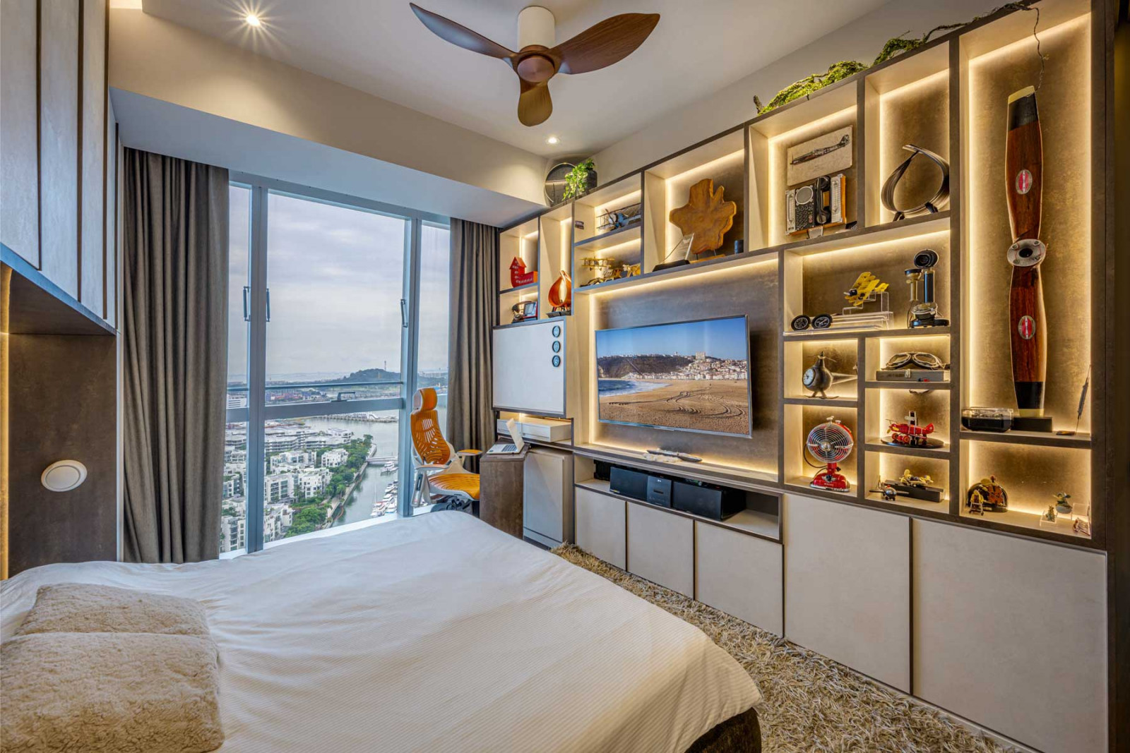 Mellow backlighting subtly calls attention to the homeowner’s beloved keepsakes, displayed on this commodious shelving unit in the master suite