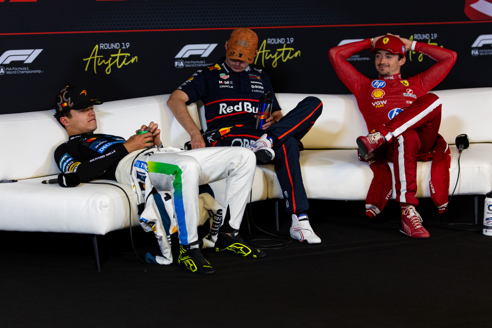 AUSTIN, TEXAS - OCTOBER 19: Lando Norris of Great Britain and McLaren sits on the sofa in the FIA press conference alongside Max Verstappen of the Netherlands and Oracle Red Bull Racing and Charles Leclerc of Monaco and Ferrari during the F1 Grand Prix of United States at Circuit of The Americas on October 19, 2025 in Austin, Texas. (Photo by Kym Illman/Getty Images)