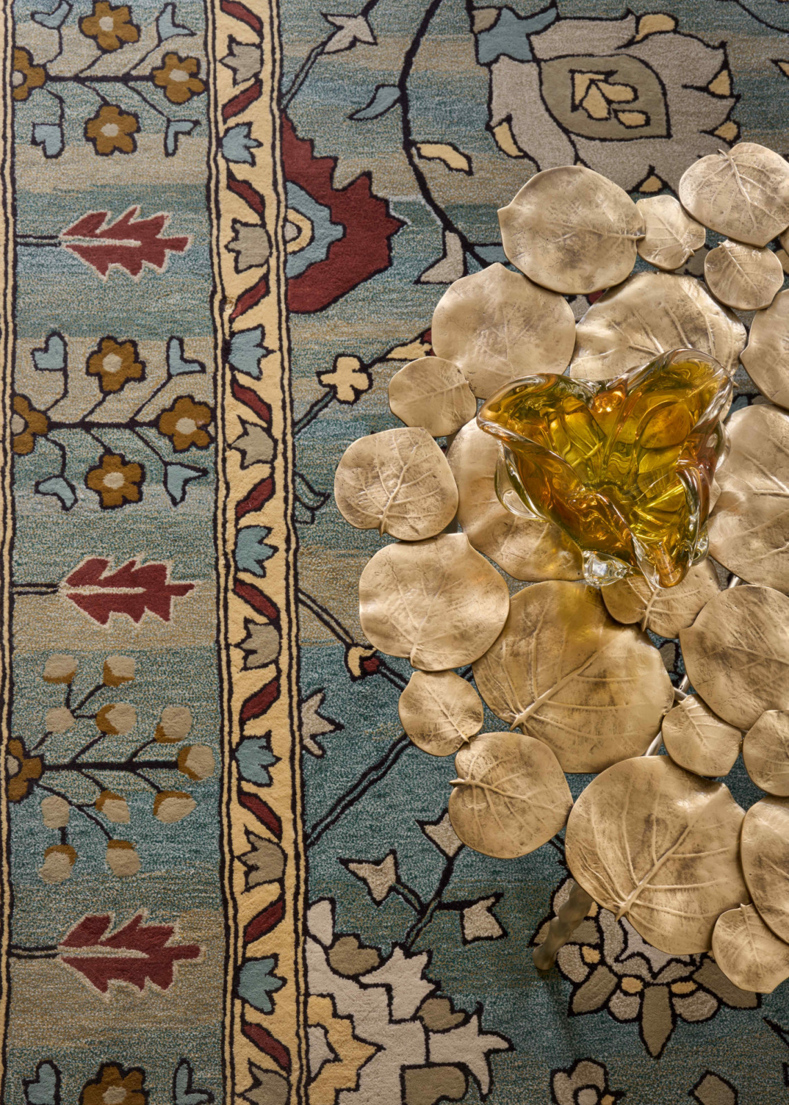 Layered richness amidst gold accents from the Hamilton Conte coffee table and a custom rug produced by Ulgador