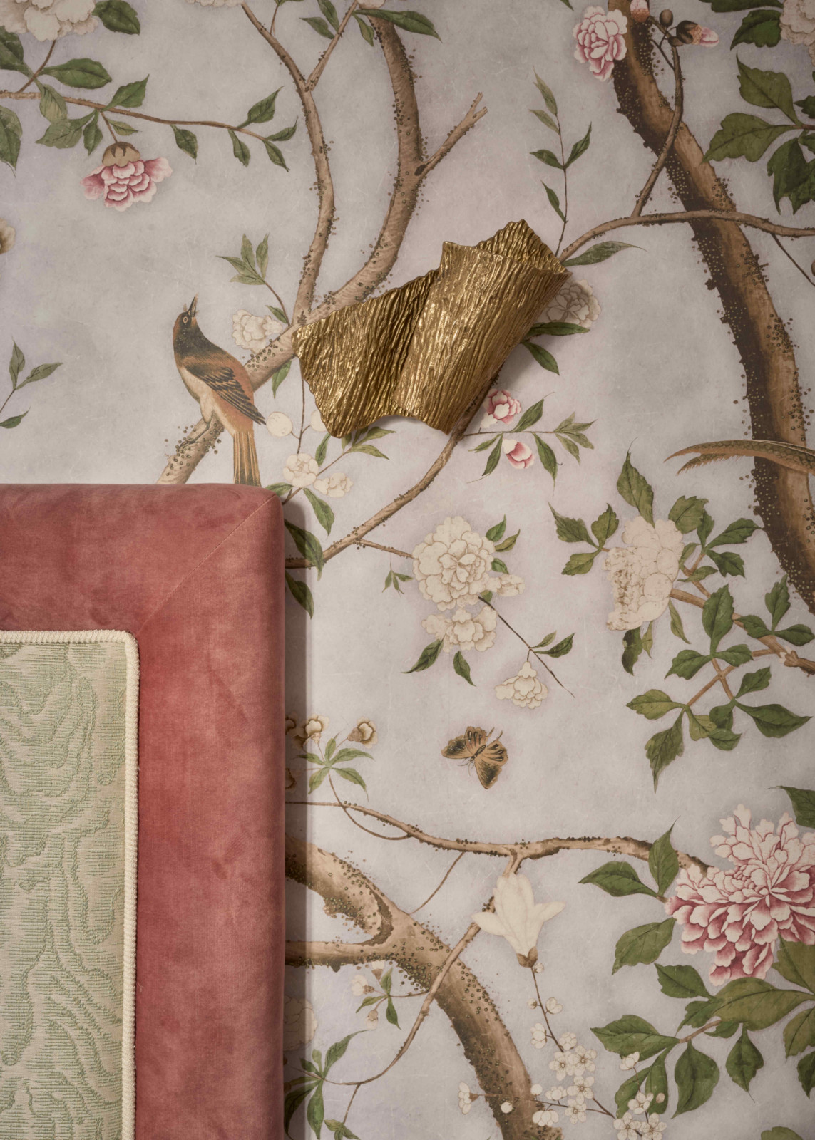 An antique sconce with gold accents complement the layered richness through silk fabrics, velvets, and damasks