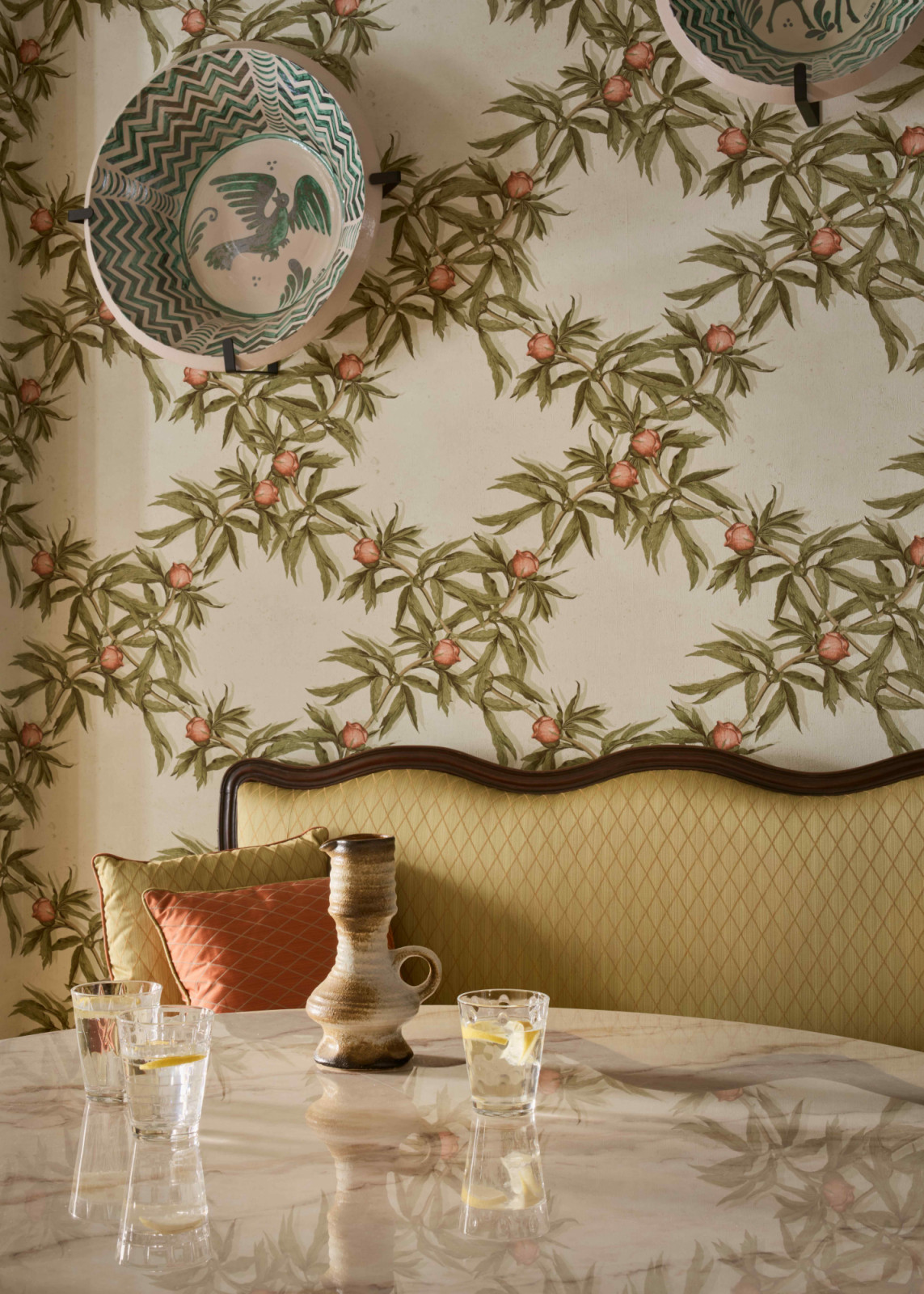 Decorative antique plates set against the nature-inspired Gaston y Daniela wallpaper