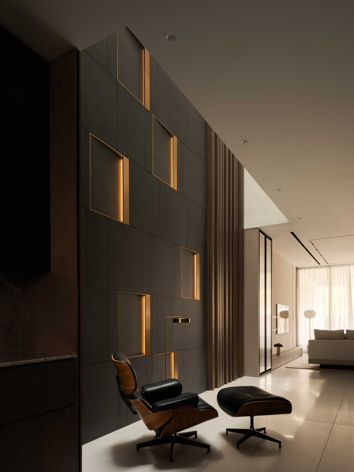 Behind the stylish Eames lounger is the feature wall, which stretches across the home’s four levels