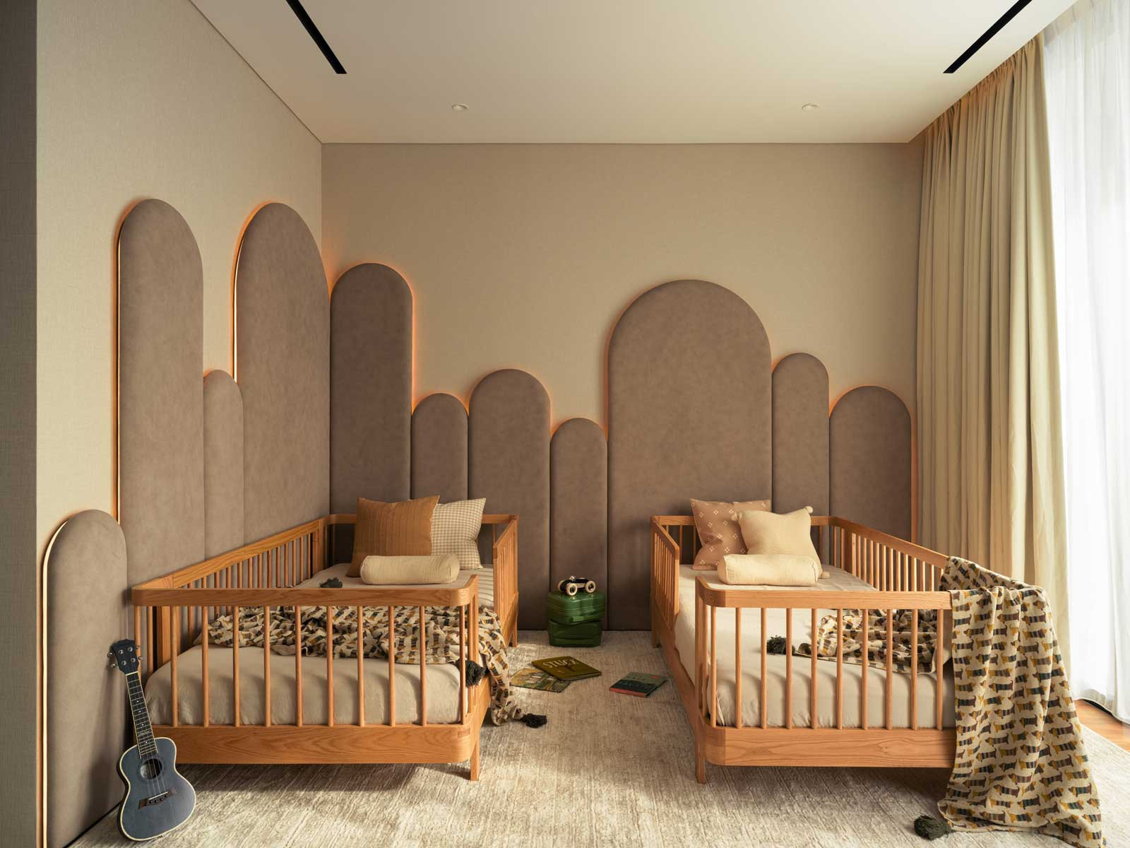 Arched cushioned wall panels in the twins’ shared bedroom provide both childproofing and acoustic comfort