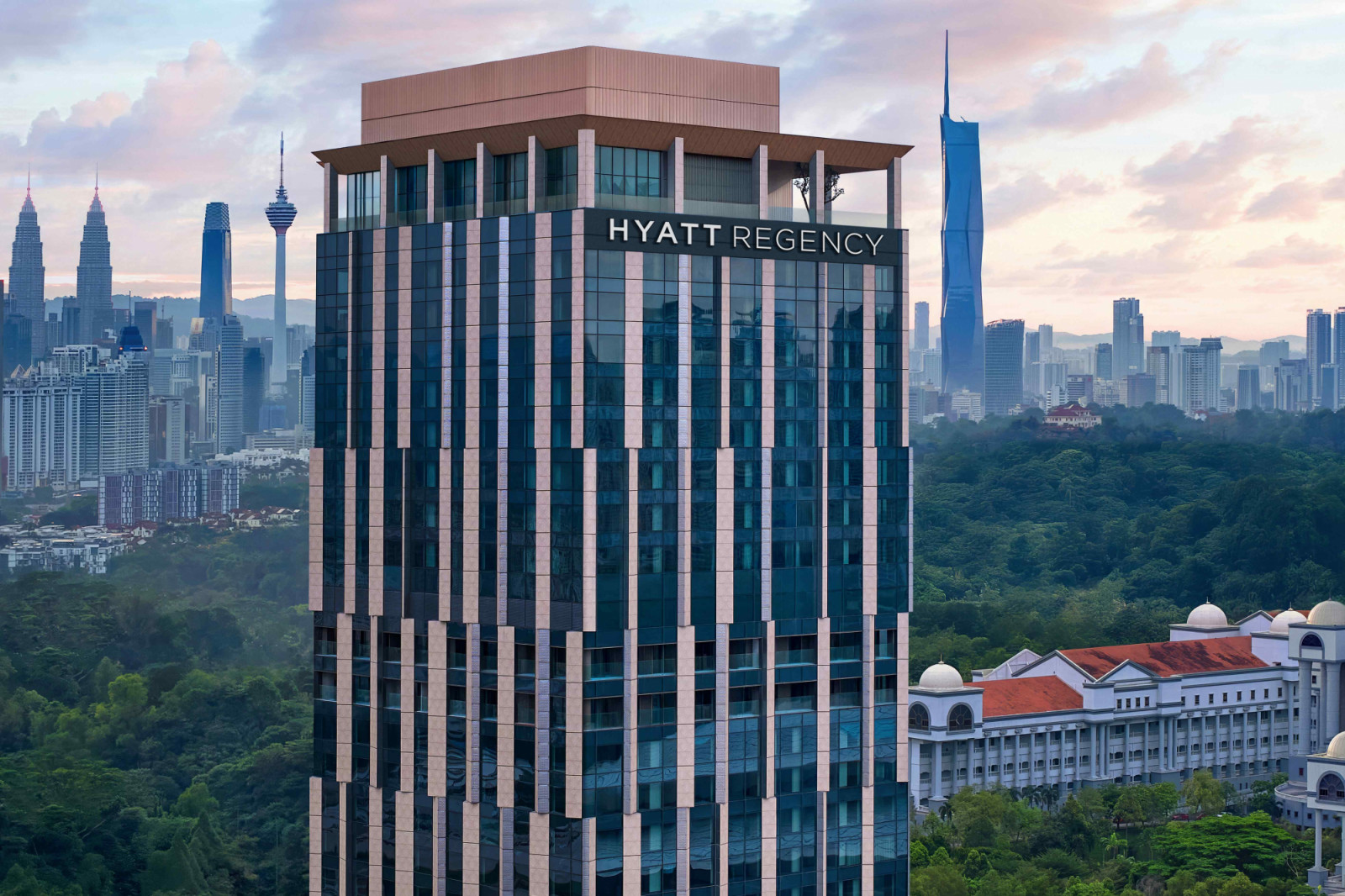 Inspired by Malaysia’s rainforests, the façade features offset vertical columns alternating between glass and aluminium to represent diverse flora and fauna