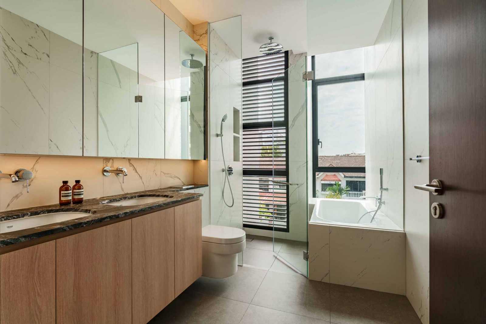One of the bathrooms, flooded with natural light and finished with textured stone and warm timber