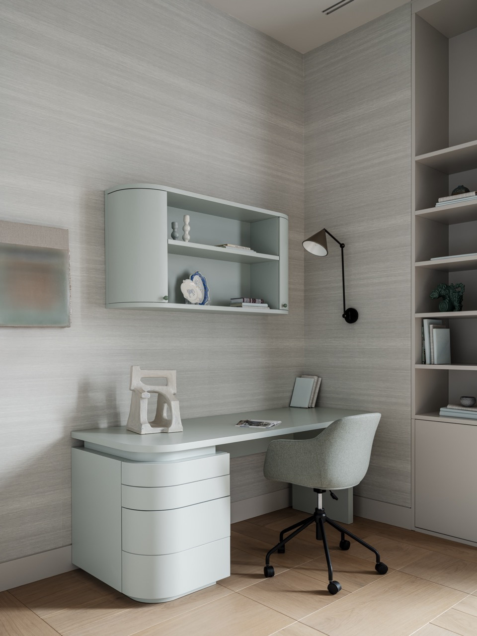 The daughter’s study area has a custom curved desk by Point Woodcraft, an upholstered chair, and a wall-mounted sconce in soft grey tones
