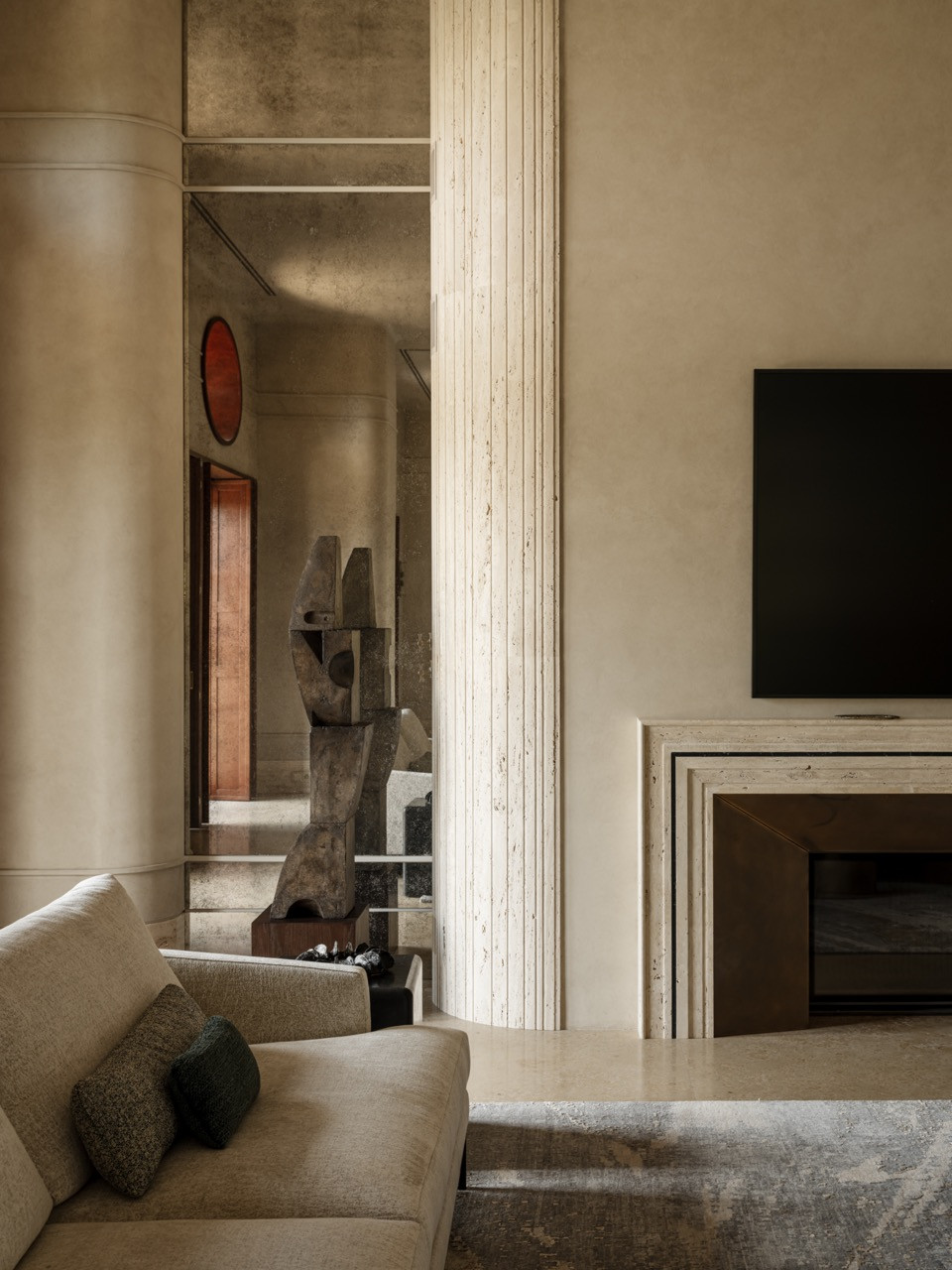 The curved sofa, custom brass coffee tables, and travertine fireplace with patinated brass details form a sophiticated tableau