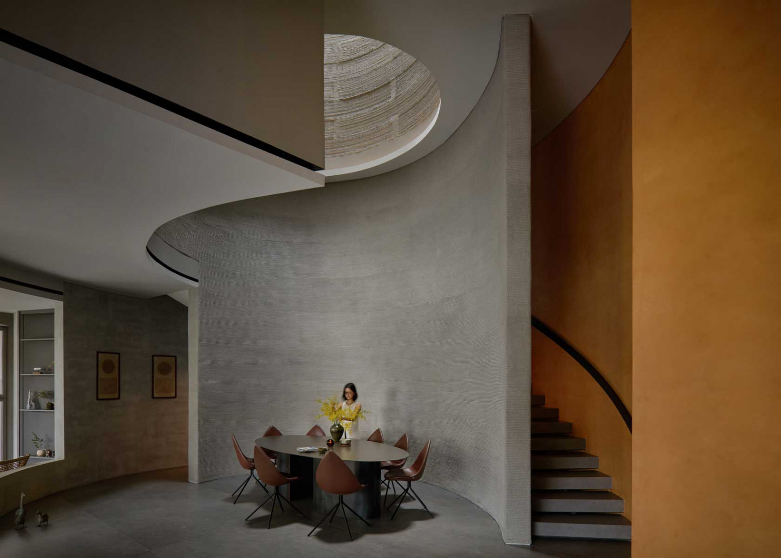 Beneath the six-metre oculus, the dining area is cradled by sweeping 3D-printed walls and a curved stairwell, expressing the sculptural and spatial ambition of Singapore’s first 3D-printed house