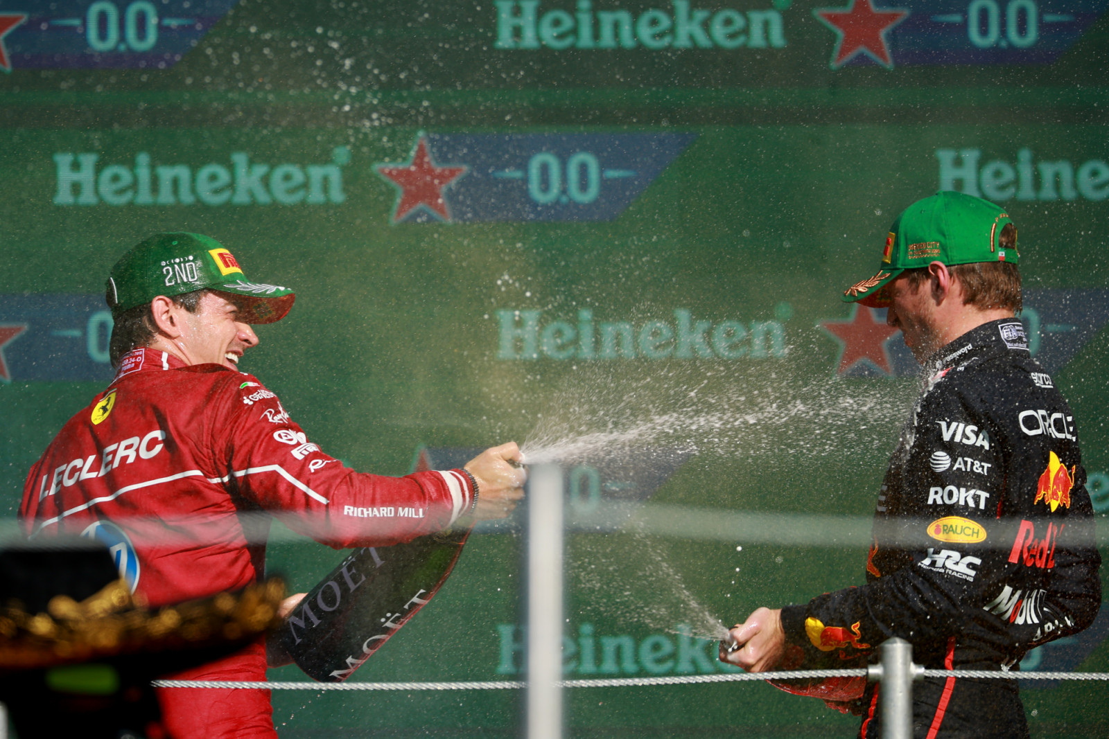 MEXICO CITY, MEXICO - OCTOBER 26: Second placed Charles Leclerc of Monaco and Scuderia Ferrari and Third placed Max Verstappen of the Netherlands and Oracle Red Bull Racing celebrate on the podium with Champagne during the F1 Grand Prix of Mexico at Autodromo Hermanos Rodriguez on October 26, 2025 in Mexico City, Mexico. (Photo by Hector Vivas/Getty Images)