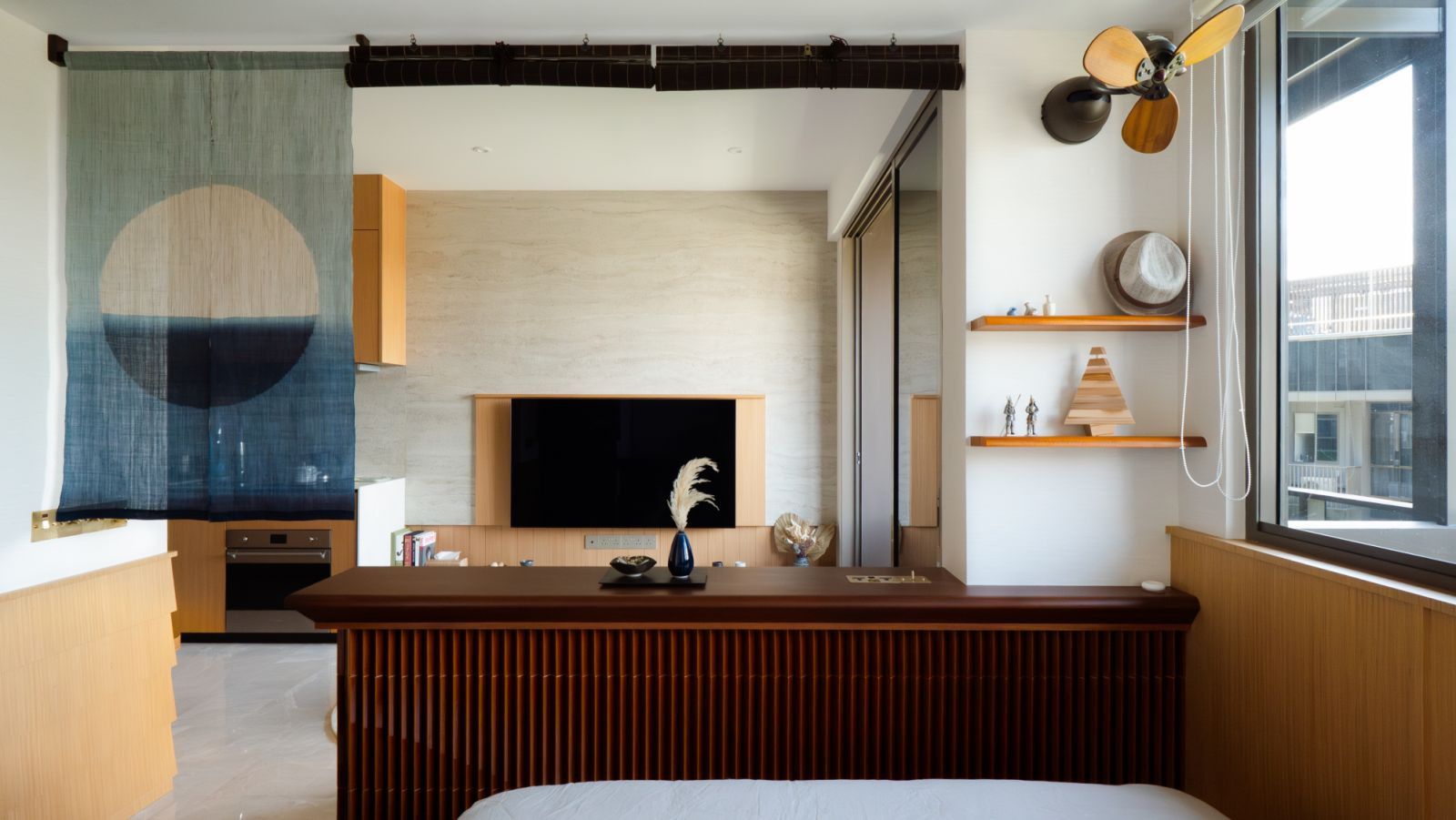 A dip-dyed noren curtain subtly demarcates the bedroom and living room, while maintaining visual openness and natural flow