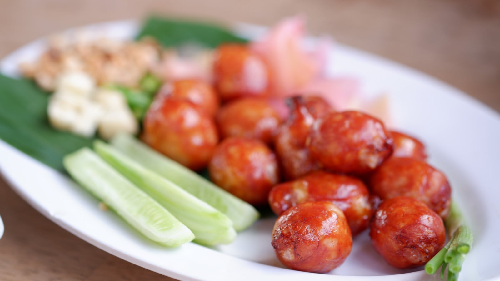 Sai krok Isan comprises ground pork, fatty pork skin and raw sticky rice with salt and garlic. After being stuffed in casings, they hang at room temperature for several days to ferment and develop its signature sour and tangy profile. (Photo: Vee Satayamas / Wikimedia Commons)