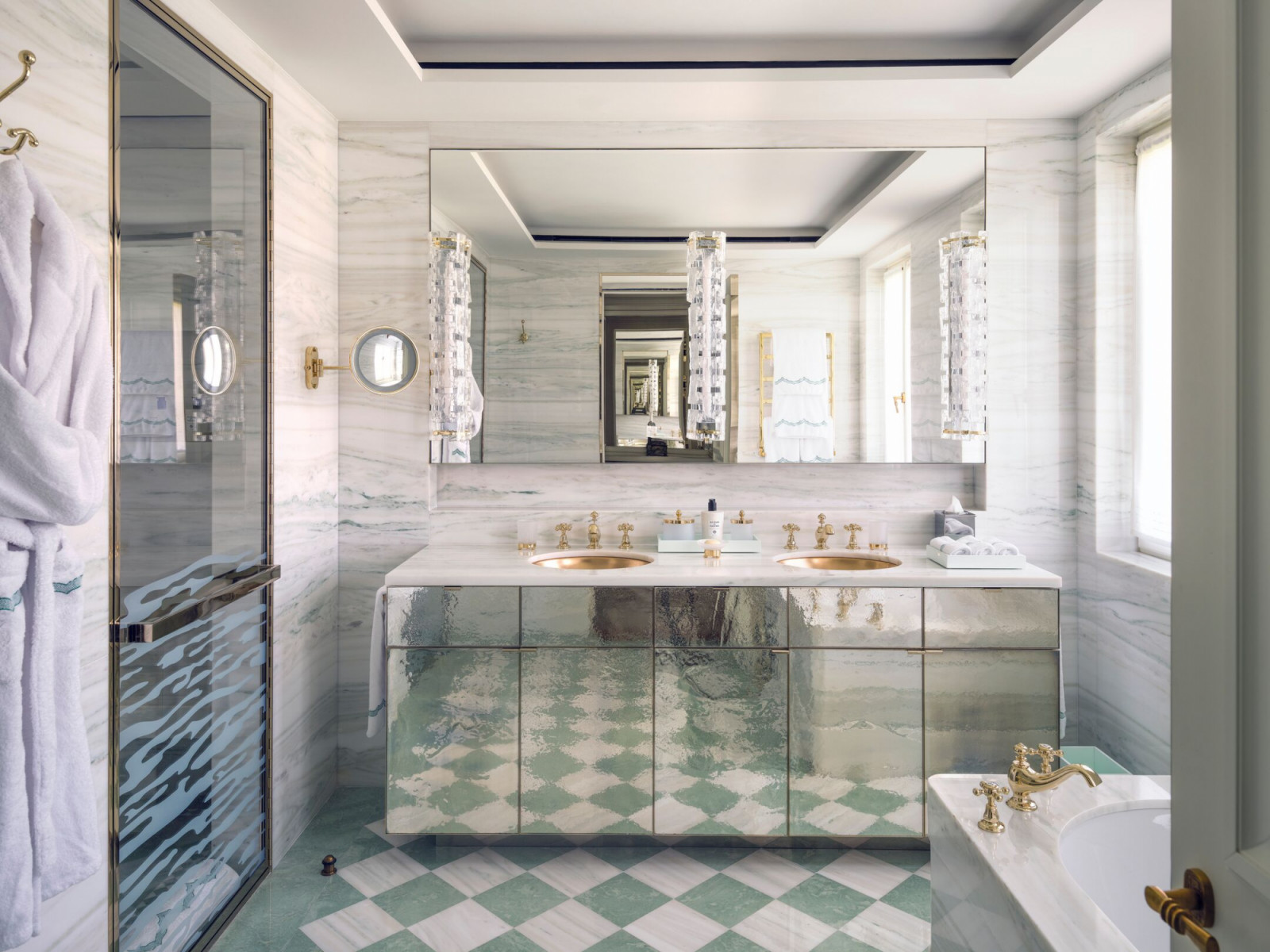 Bathroom in one of the suites featuring marble surfaces and custom cabinetry in soft green tones